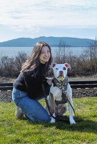 Adrienne poses with a dog outdoors