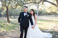 An Austin wedding photographer captures a beautiful moment of a bride and groom standing in an orchard.