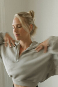 Woman moving through Kundalini breathwork, eyes closed, embodying flow and energetic release