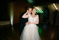 Groom embracing smiling bride on the dance floor