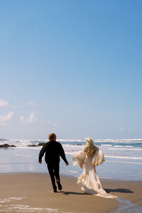 newly weds running on beach, destination wedding, eloped couple