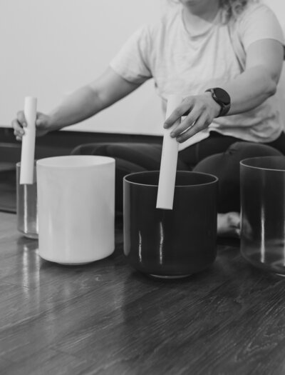fallback shared on Invalid Date | Black and white image of a person playing crystal signing bowls while sitting on a yoga 