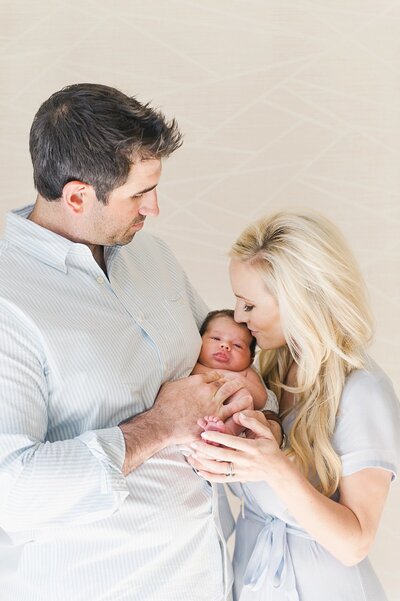 fallback shared on Invalid Date | mother and father holding a baby and kissing him on the head