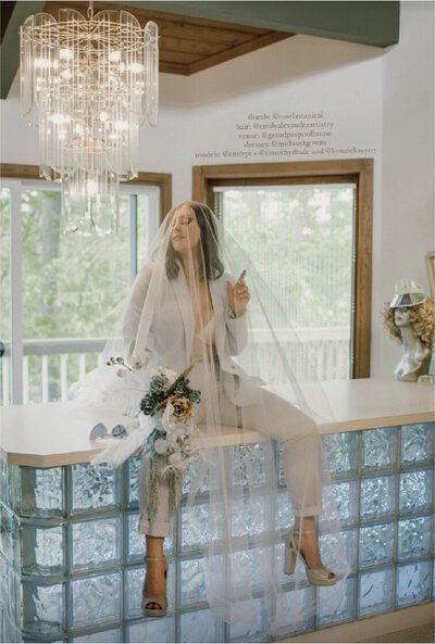 woman-in-tux-with-veil-and-flowers