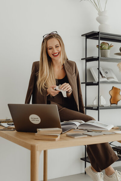 kaboompics_young-entrepreneur-dressed-in-brown-suit-holds-laptop-video-call-27946
