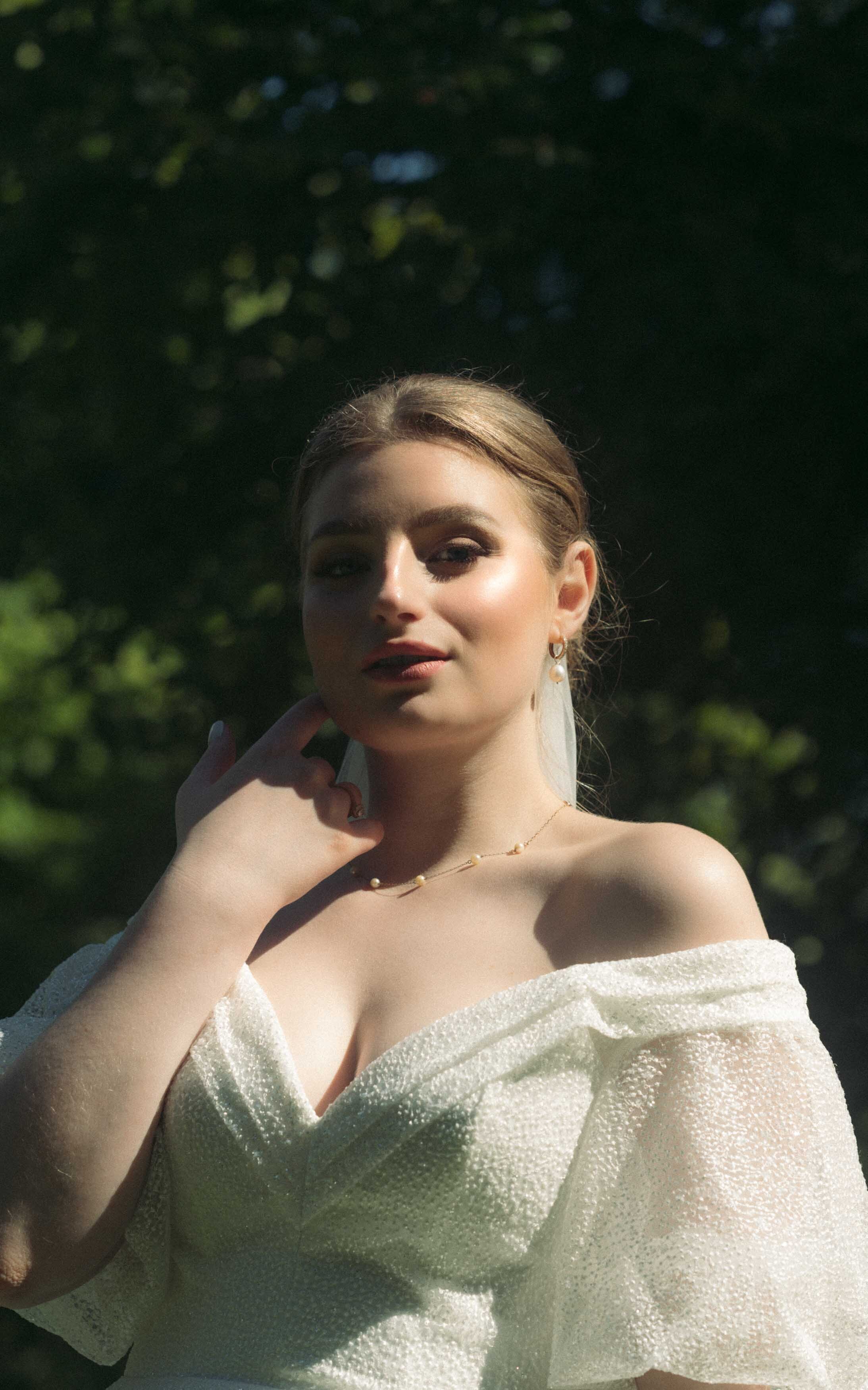 A stylish modern bride posing confidently in her wedding dress, showcasing her beauty and elegance on her special day