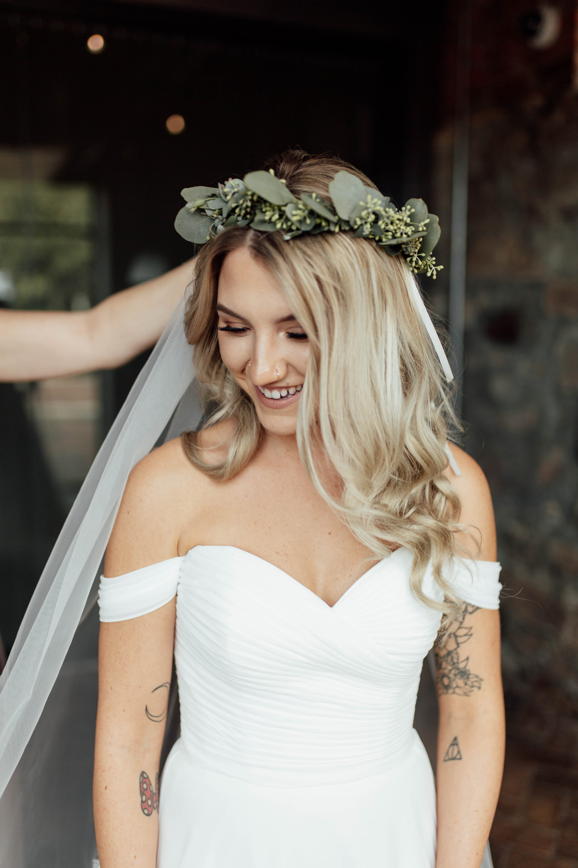 Bride putting on her veil while getting ready for the wedding ceremony.