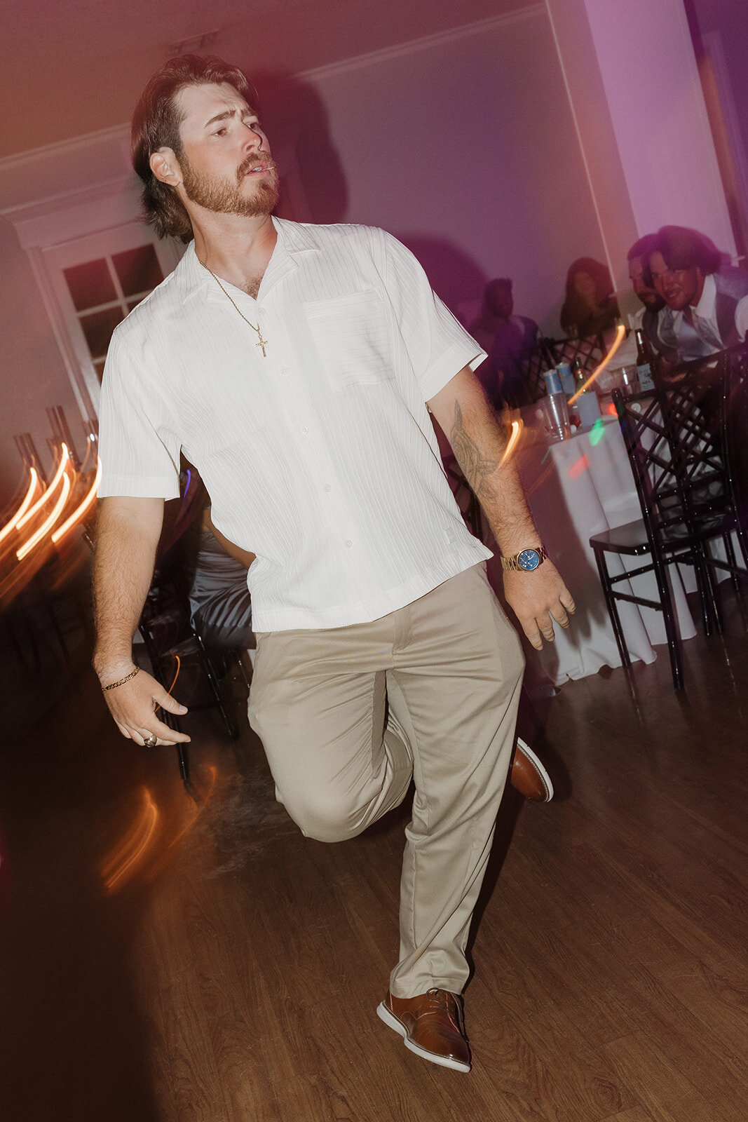 A guest dancing and kicking his leg up at the wedding reception. 