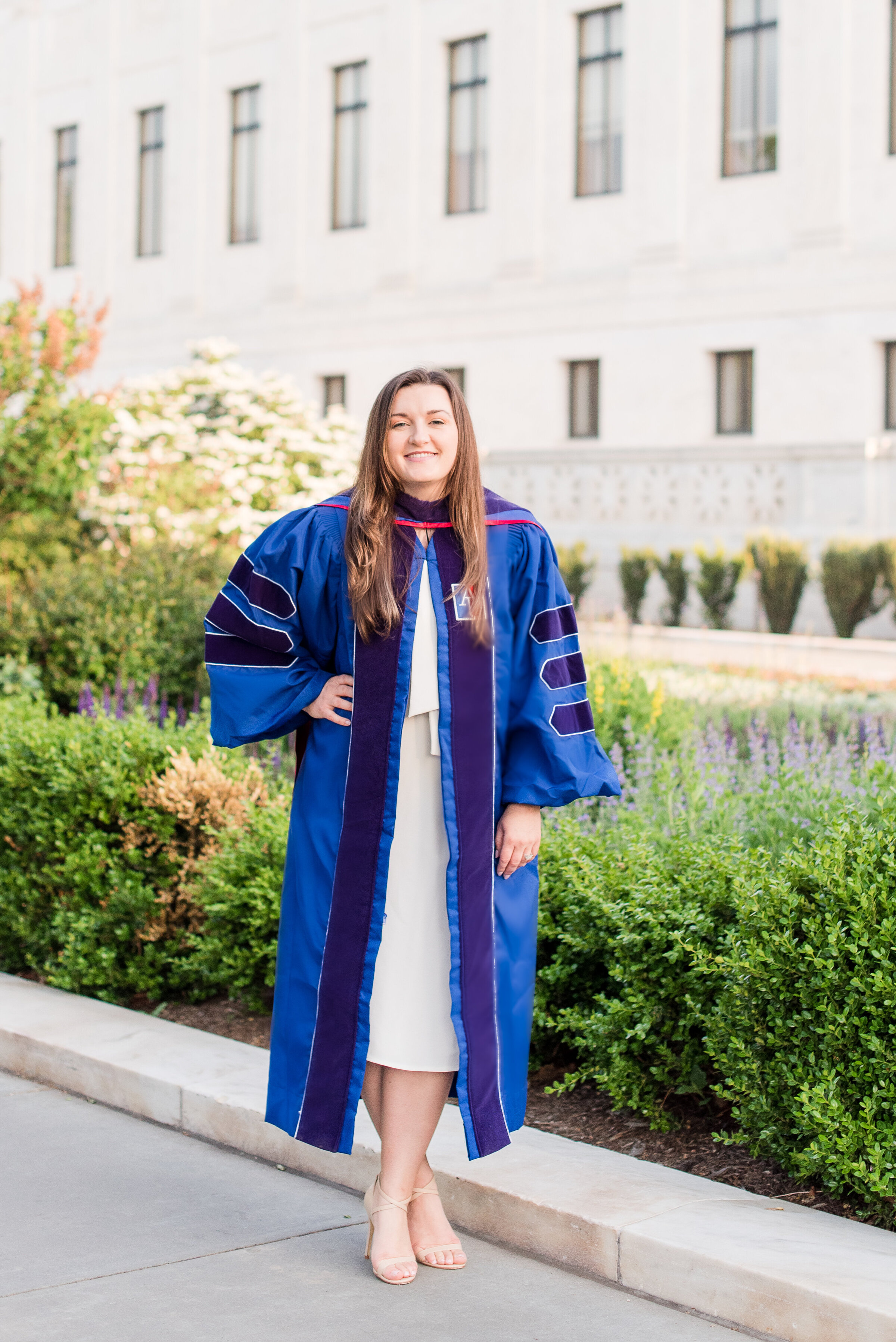 phd graduate in dc with blue regalia and white dress