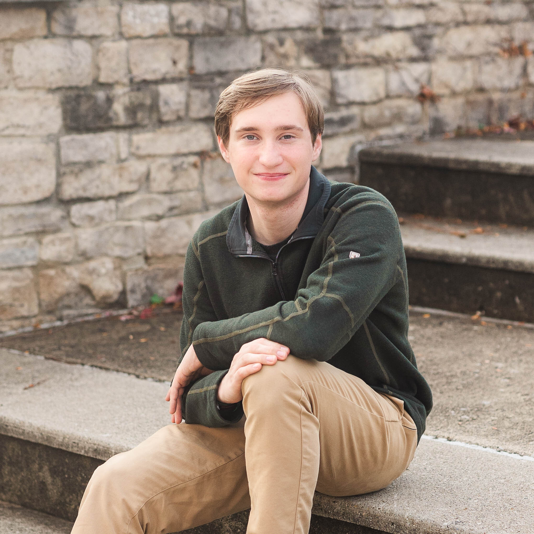 Columbus senior photos in downtown – a stylish high school senior sitting on a step in the city, captured in natural light for a modern and timeless portrait