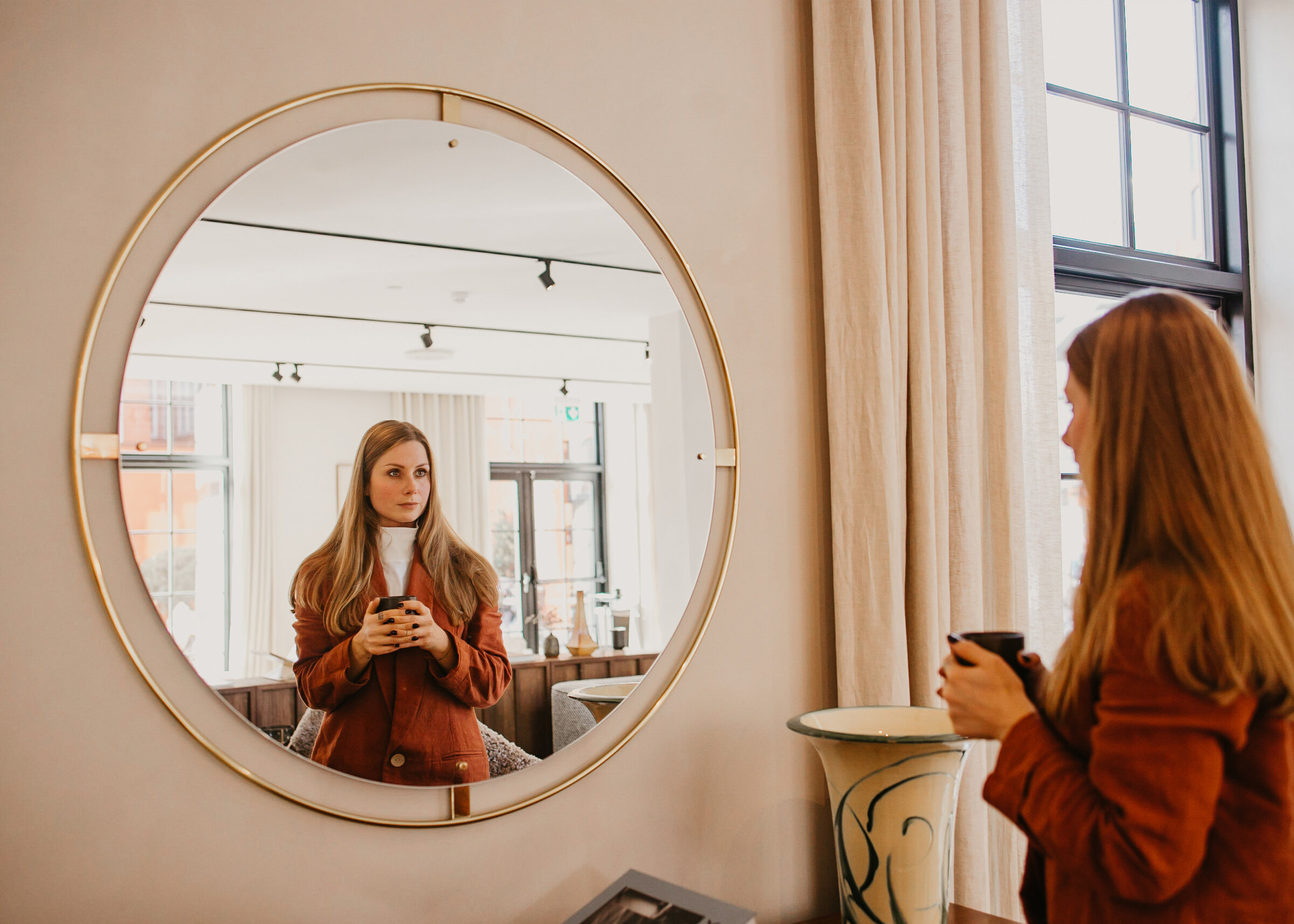 Barbora the manifestation coach looks at her own reflection in the mirror