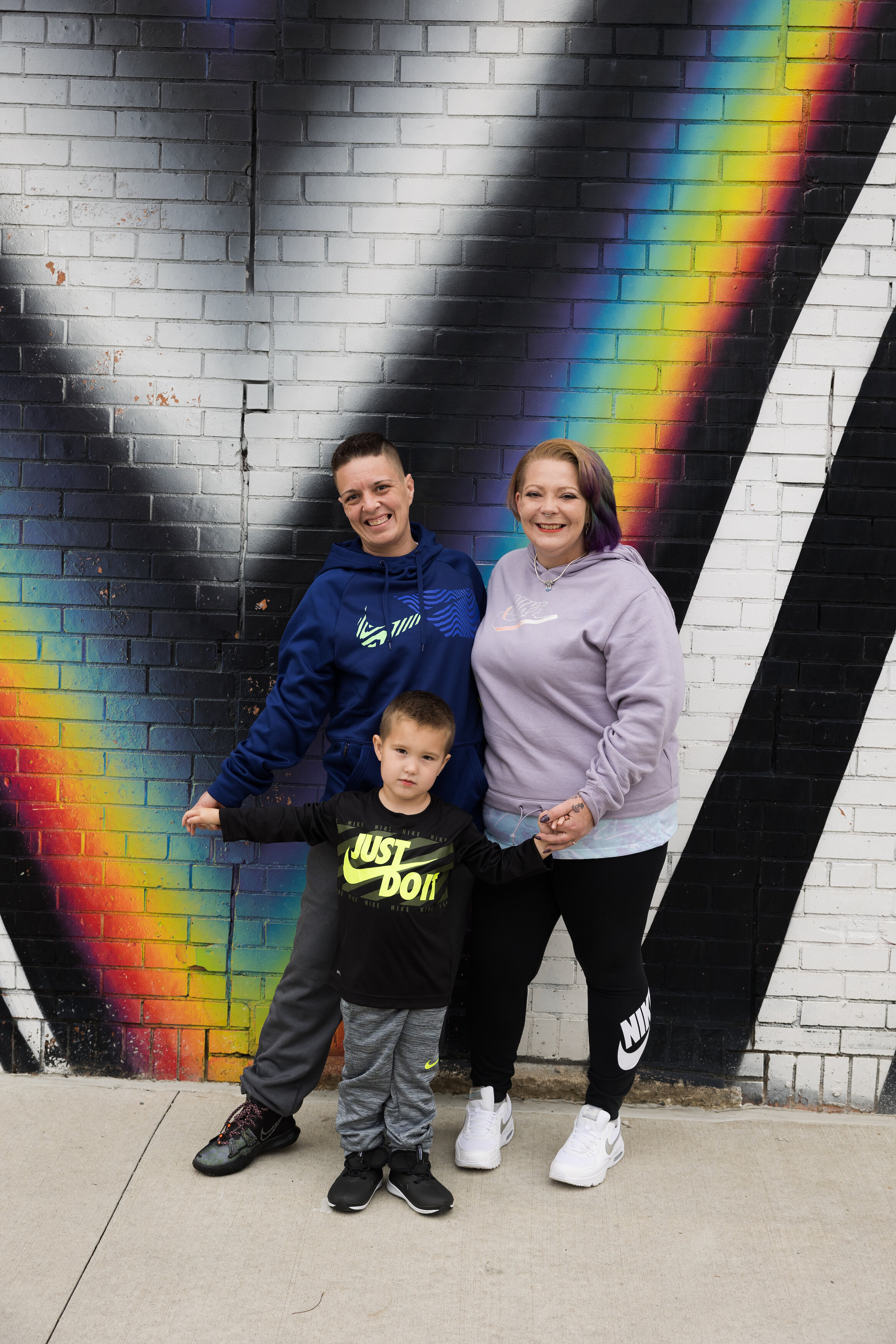 LGBTQ+ family in front of rainbow wall in Ferndale MI