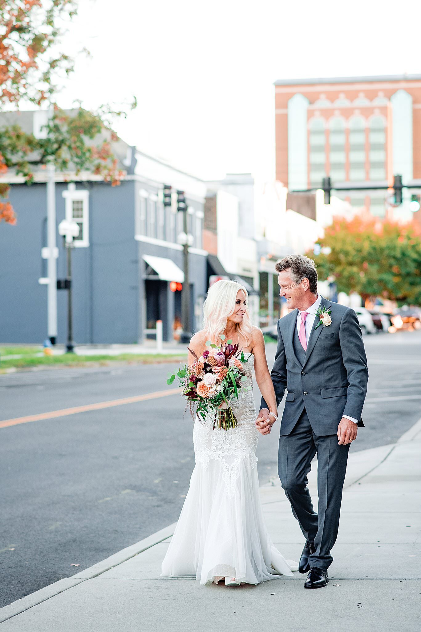 Bride and Groom holding hands walking down the sidewalk in Murfreesboro after their ceremony