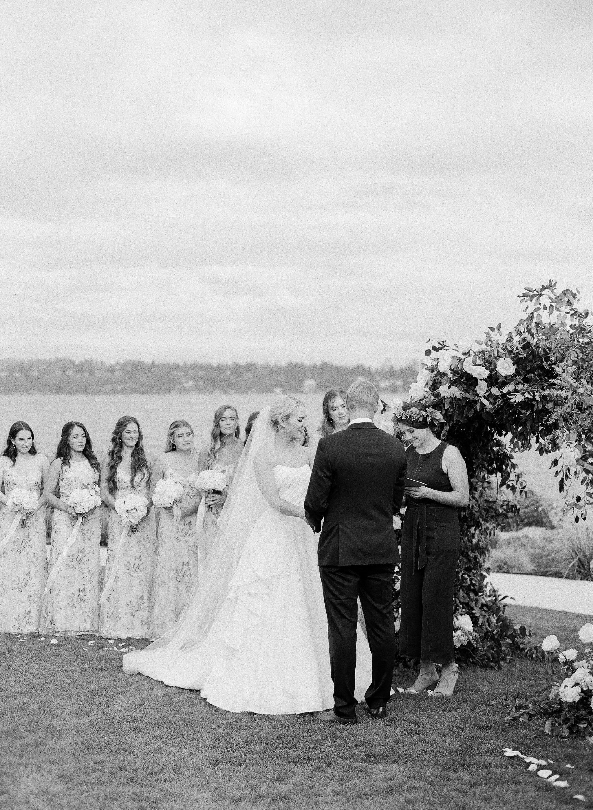 black and white film photo of a wedding ceremony on a lake