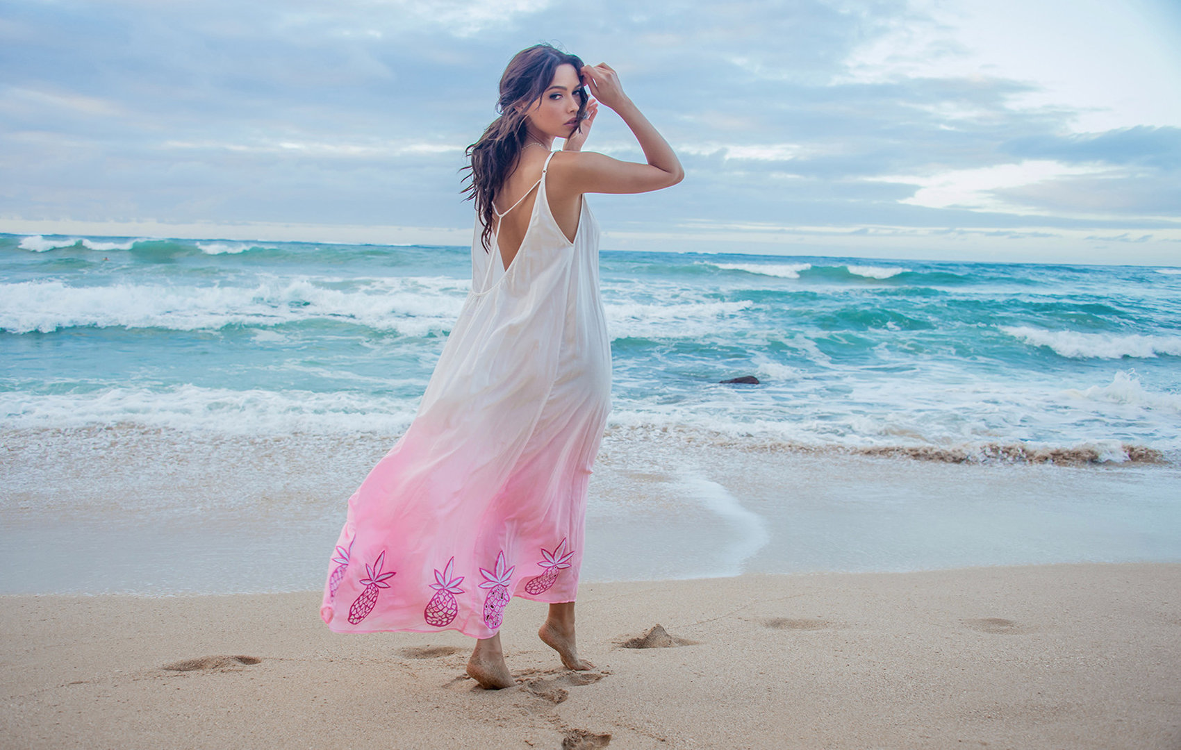 Model wearing an Aloha dress on the beach on MAUI, blowing in the wind.