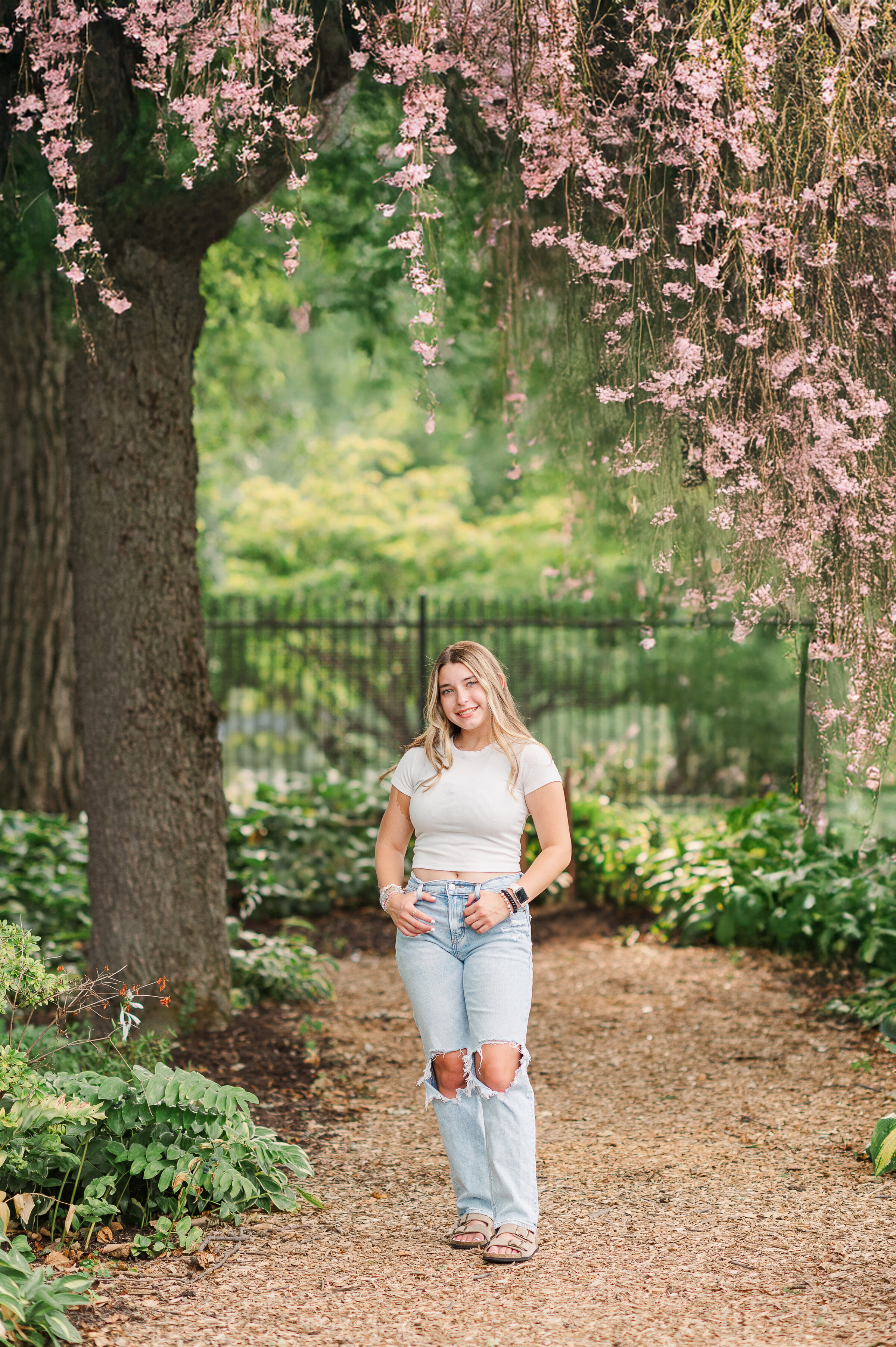 Senior girl in a forested area wearing a white dress at a park near Harrisburg, PA
