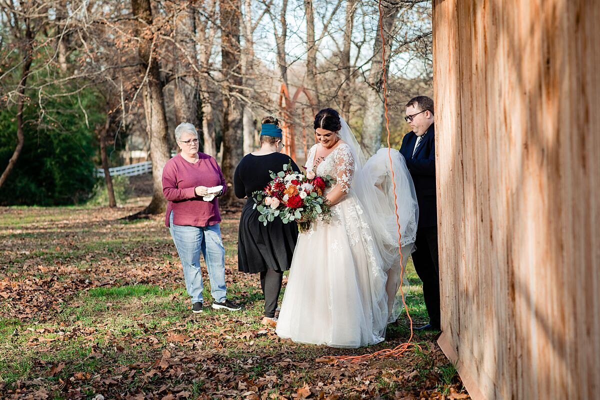 Pat helping carry the brides veil and trail outside