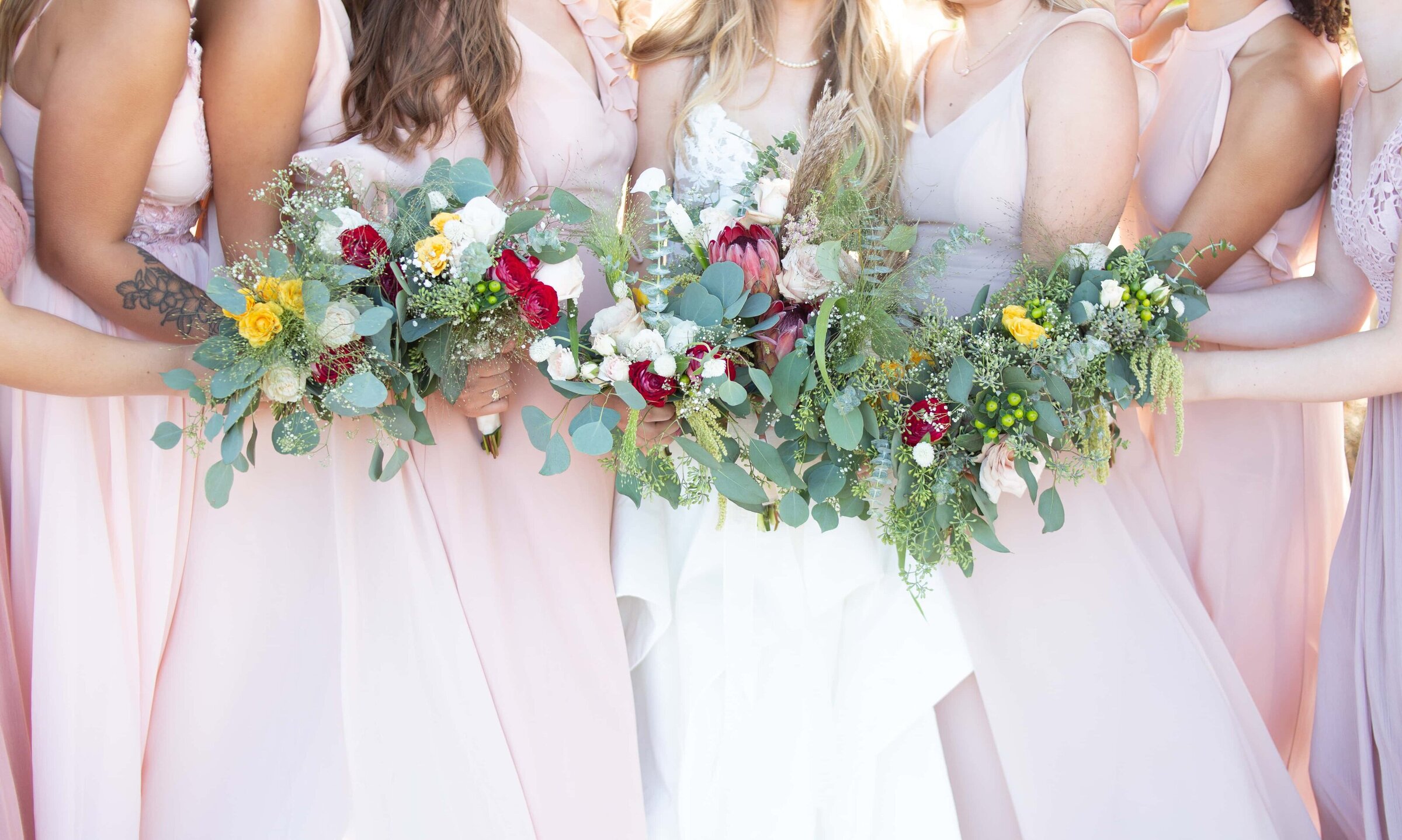 closeup of bridesmaids holding colorful flowers at Merrimon-Wynne in Raleigh, NC.