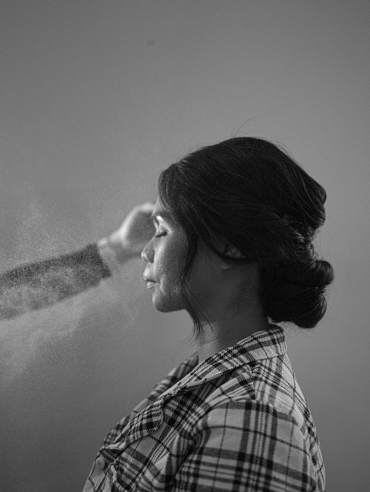 Black and white image of a bride getting her makeup done before her Nashville wedding