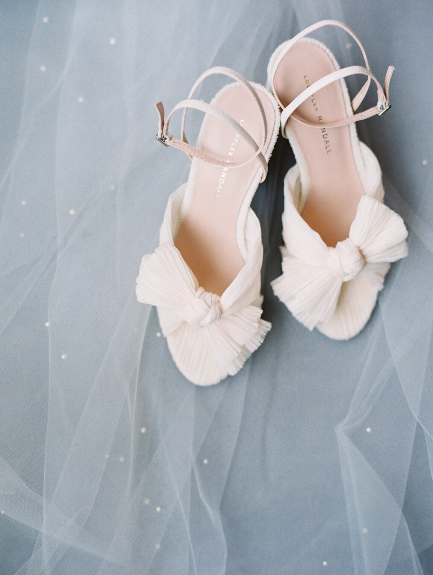 white bridal shoes on blue backdrop