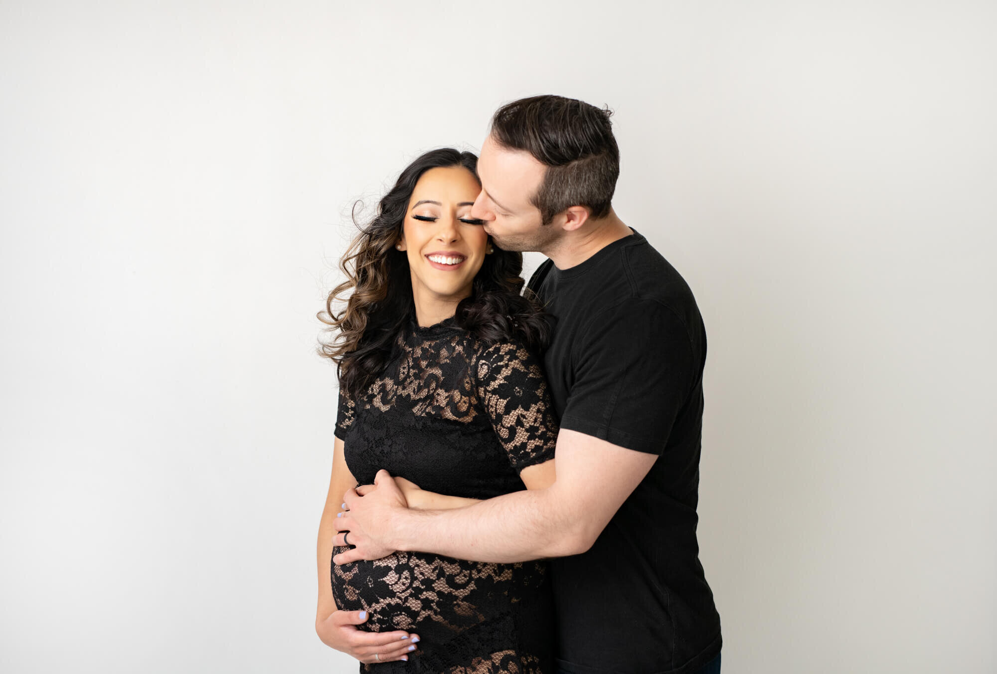 Laughing expectant couple with white background