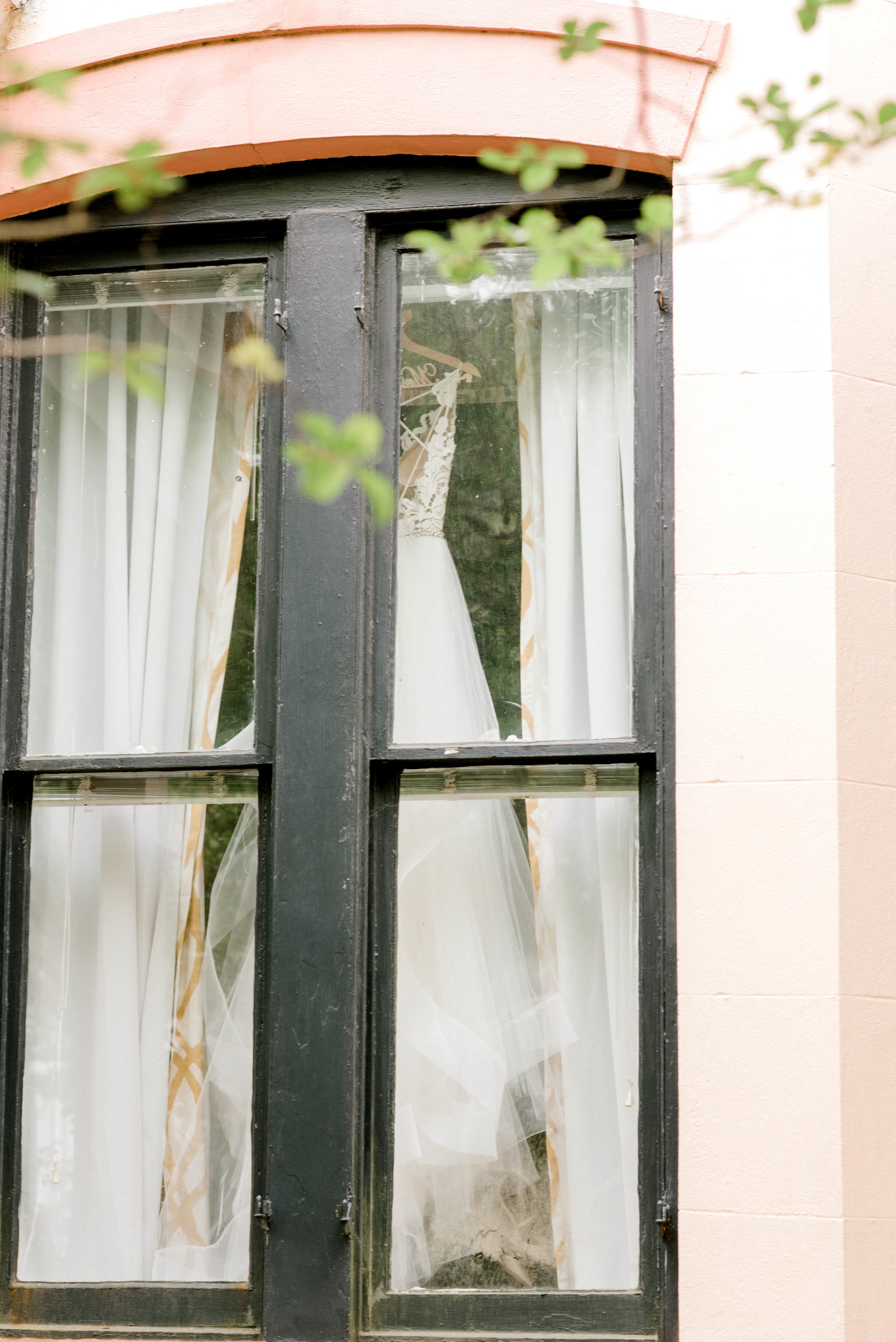 Wedding Gown hanging in window Ivory and Beau