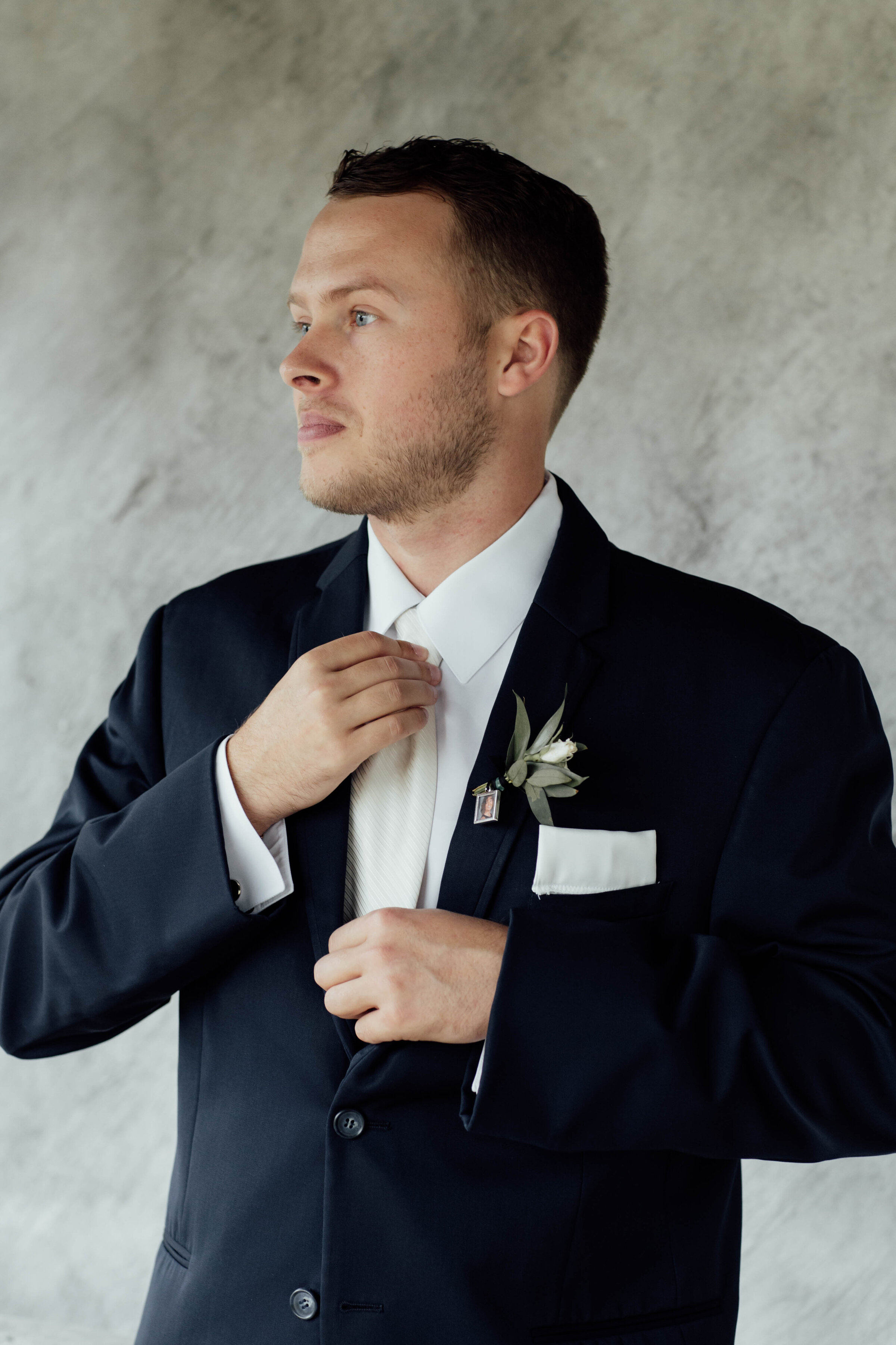 Groom fixing tie before walking down the aisle. 