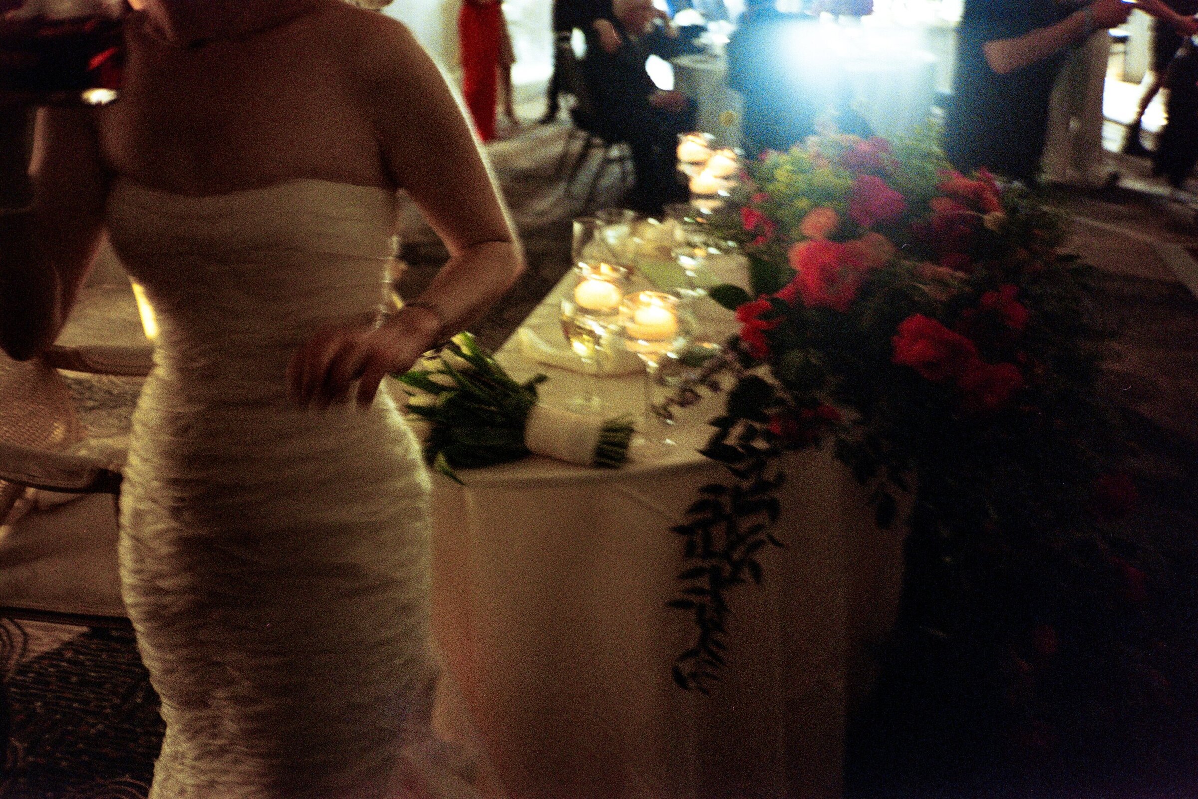Grainy film photograph of the bride at the sweetheart table during a wedding in Potomac, Maryland.