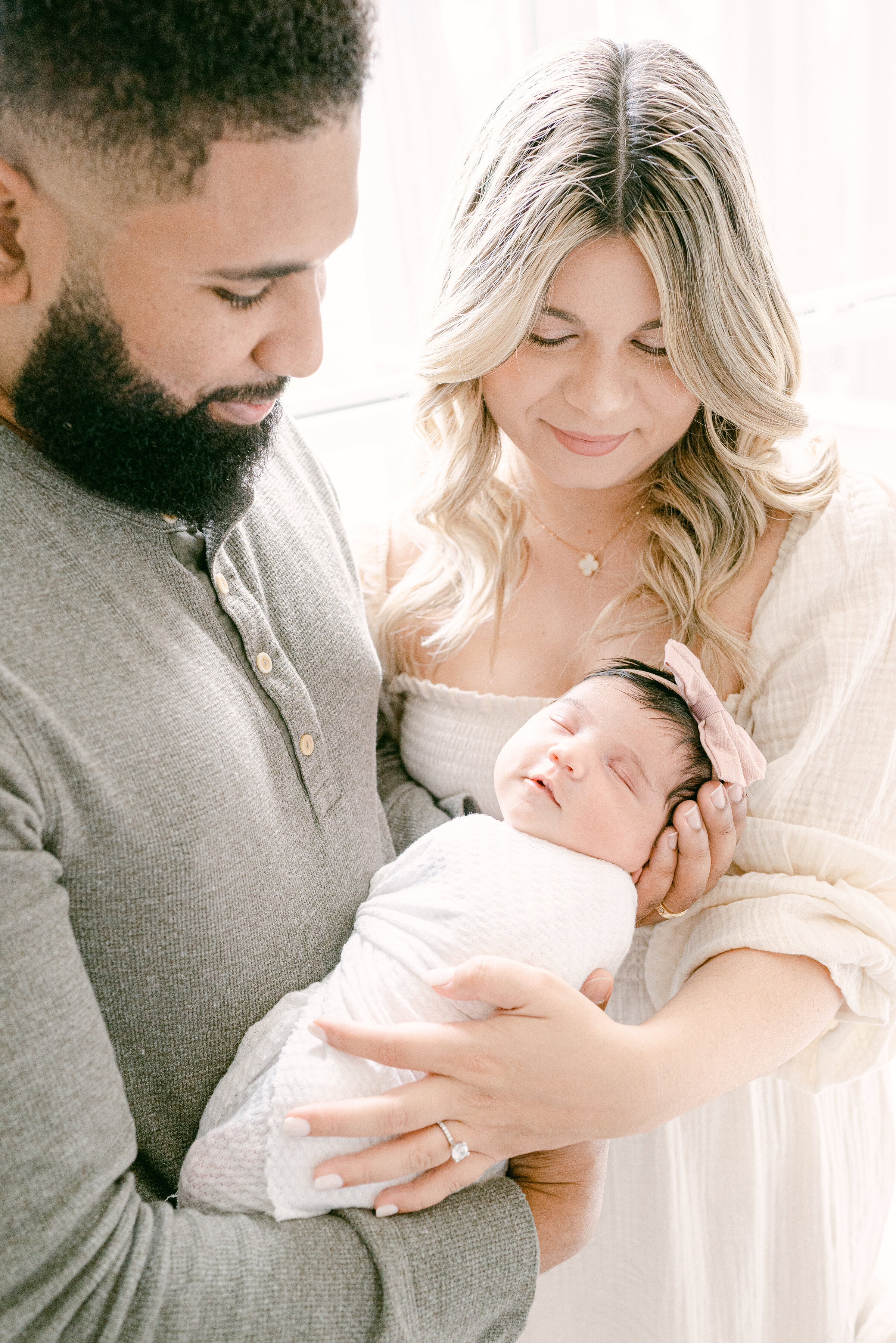 Dad and mom holding their newborn baby by Miami Newborn Photographer