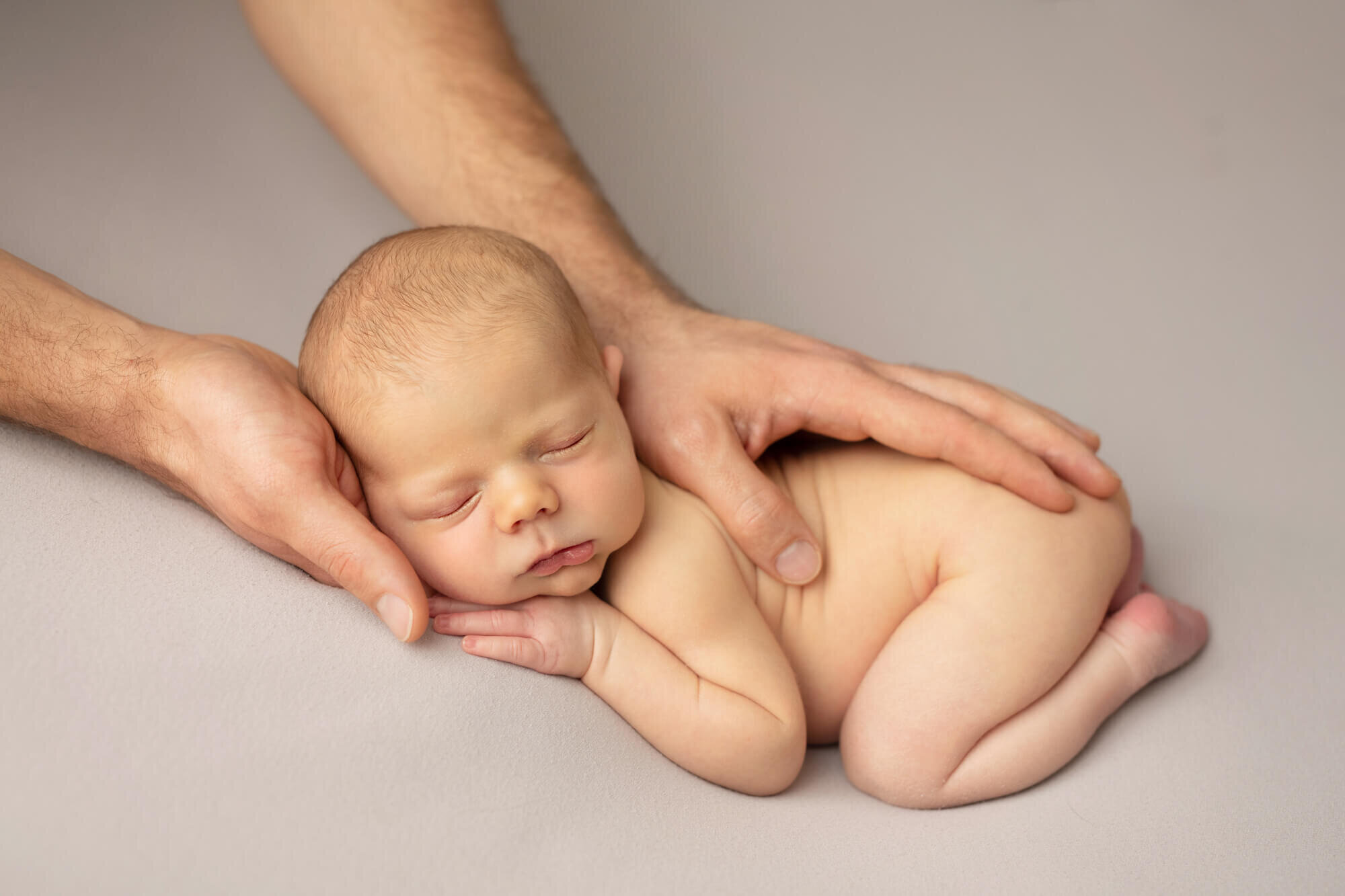 Newborn baby boy with parents hands