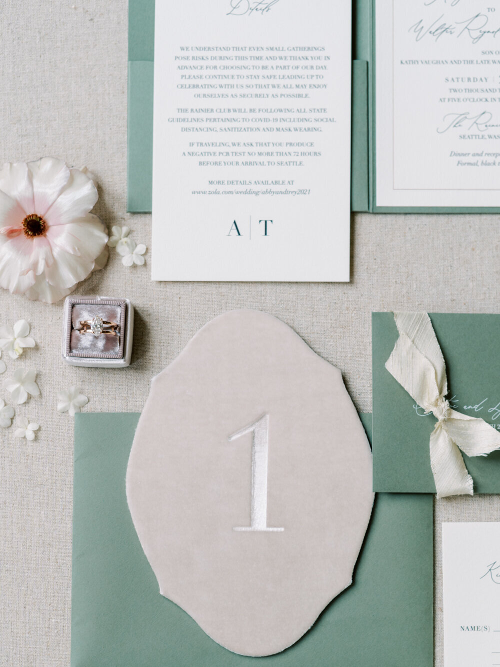 velvet wedding table numbers laid on top of sage invitations