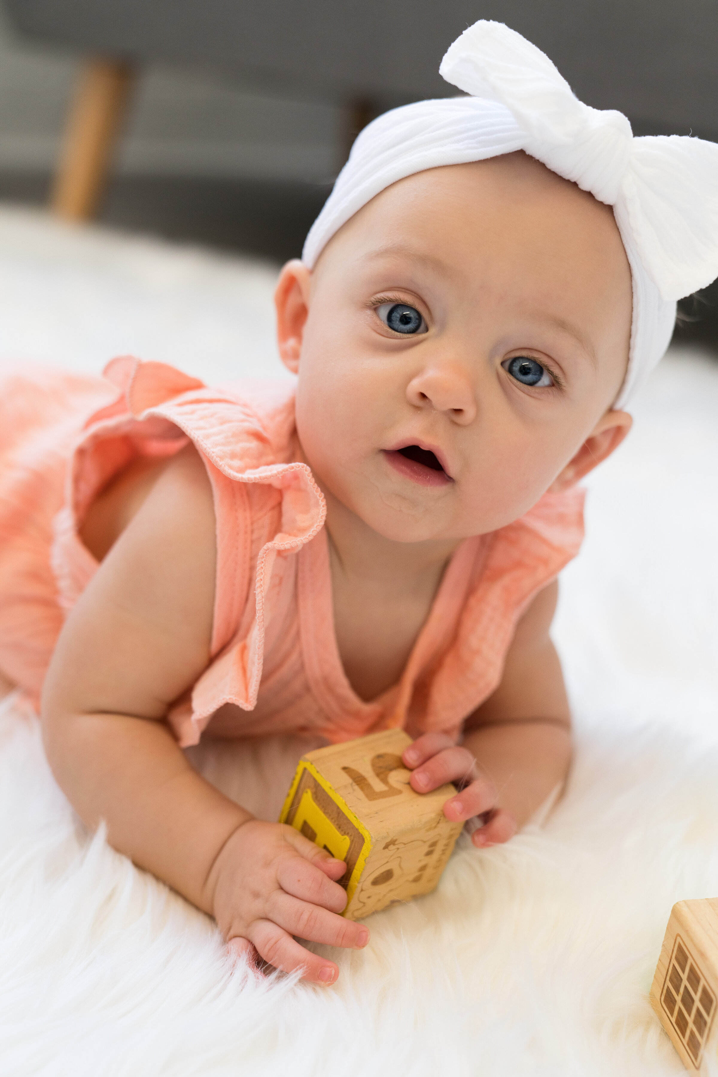 Baby laying on her stomach and playing with blocks