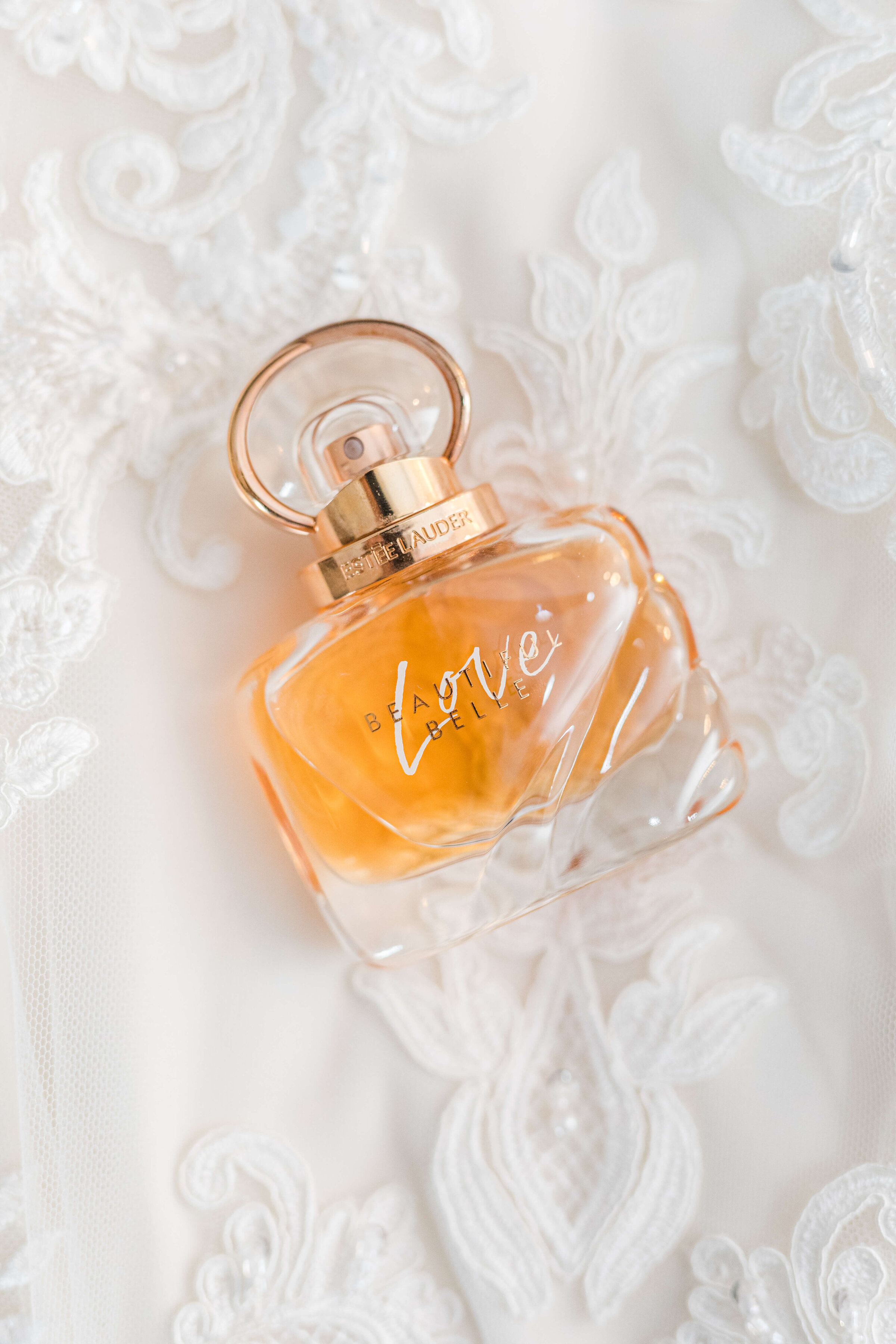 A photograph of Love perfume on top of a wedding dress