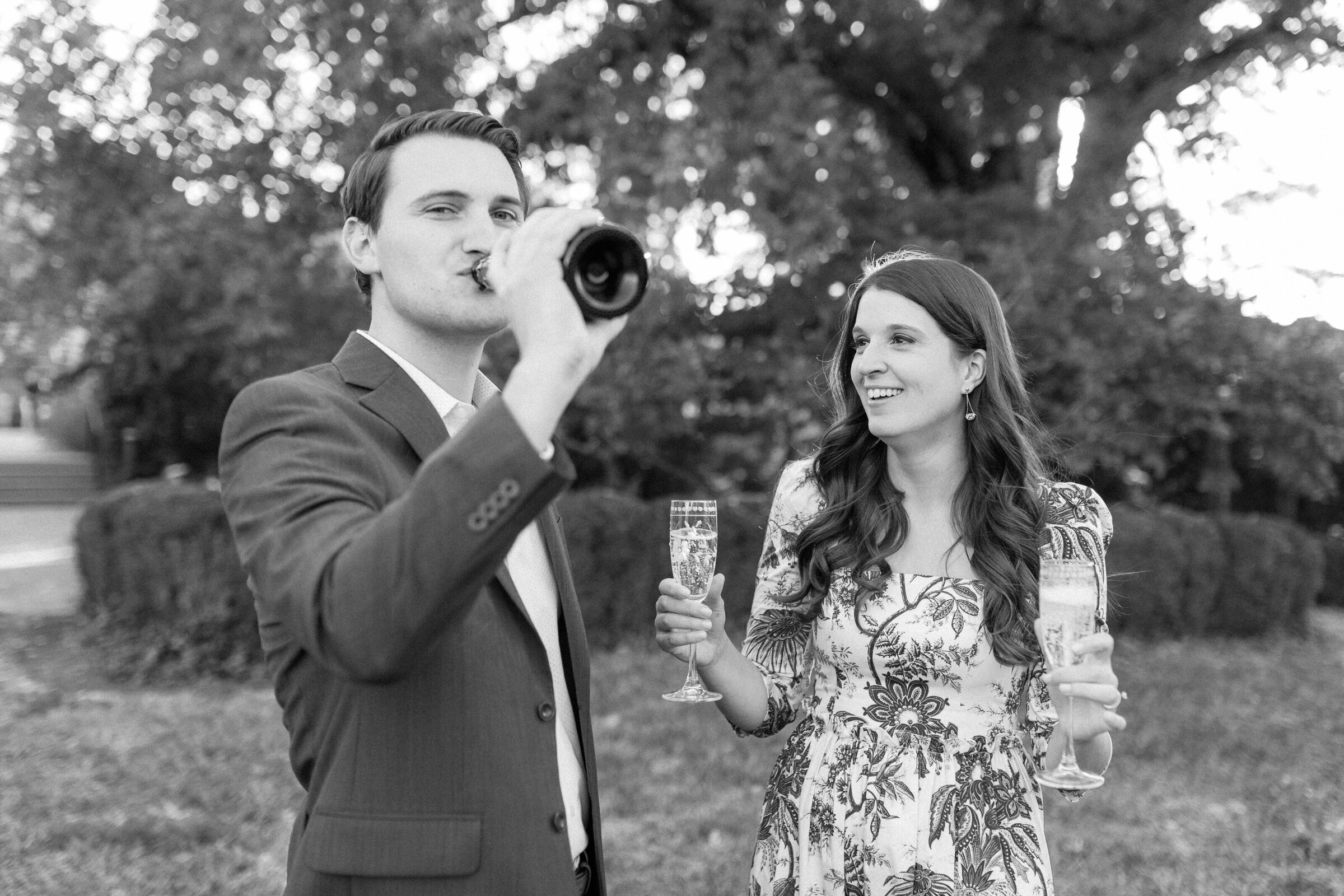 A candid moment of a couple toasting champagne during their engagement session at Ault Park.