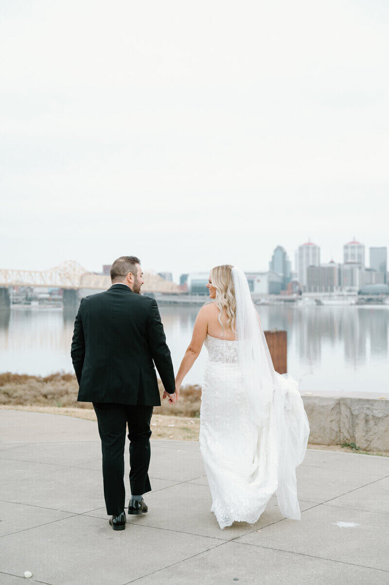 bride and groom holding hands and walking by wedding photographers lexington ky