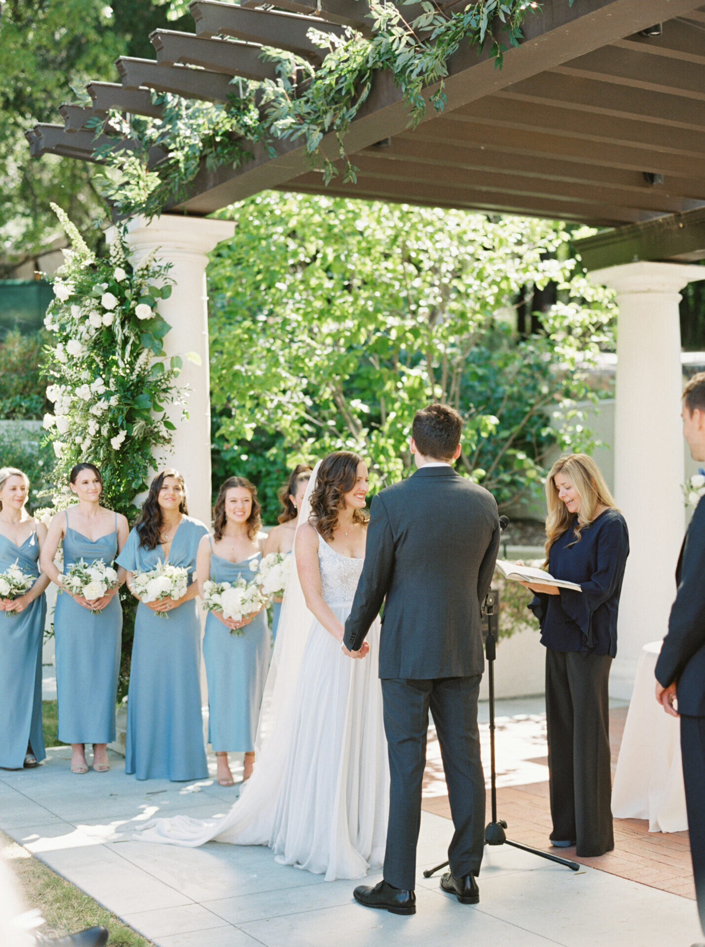 bride and groom up close holding hands during outdoor garden ceremony