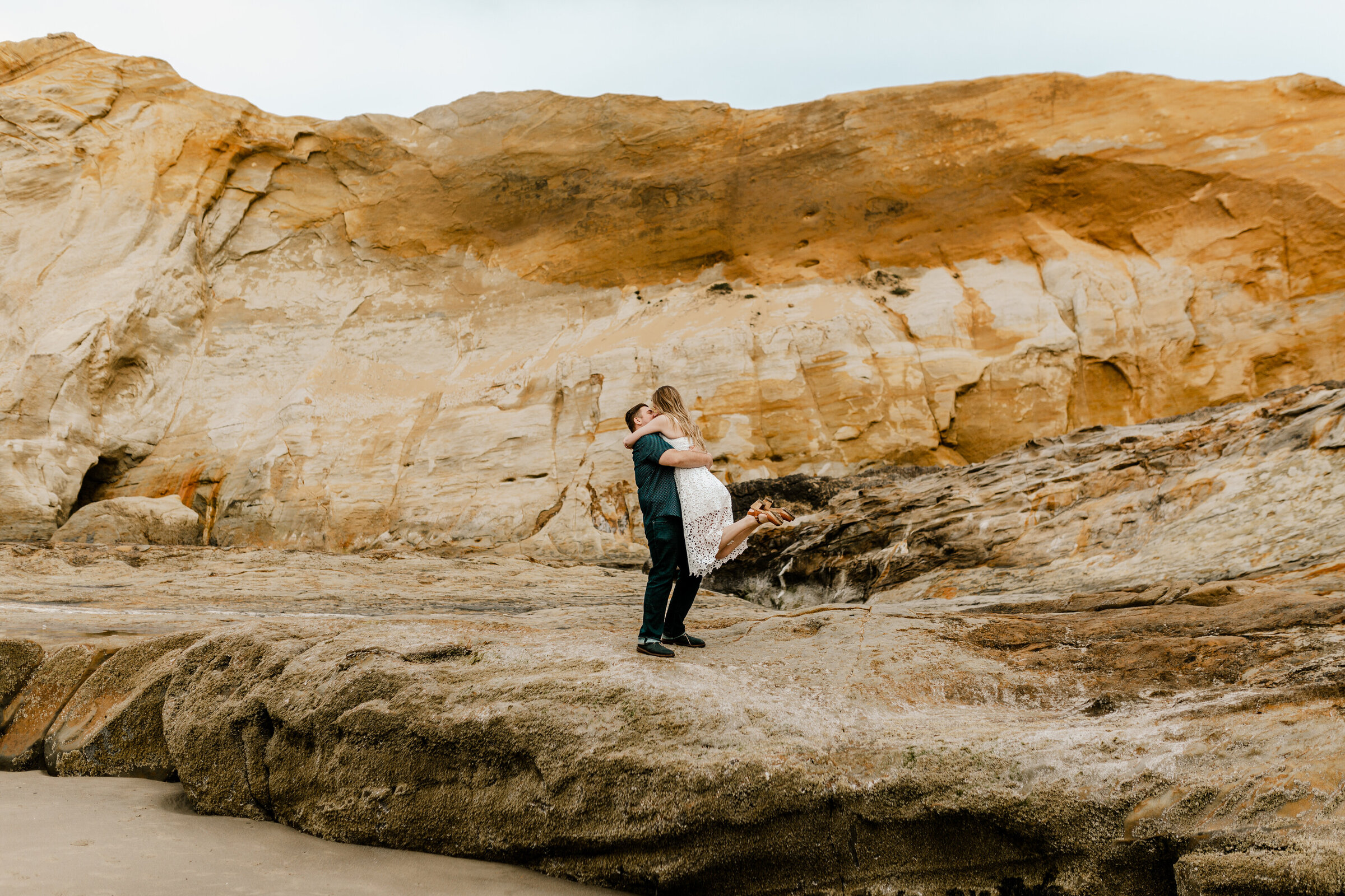 Couple embraces alongside the rocks of the Oregon Desert.