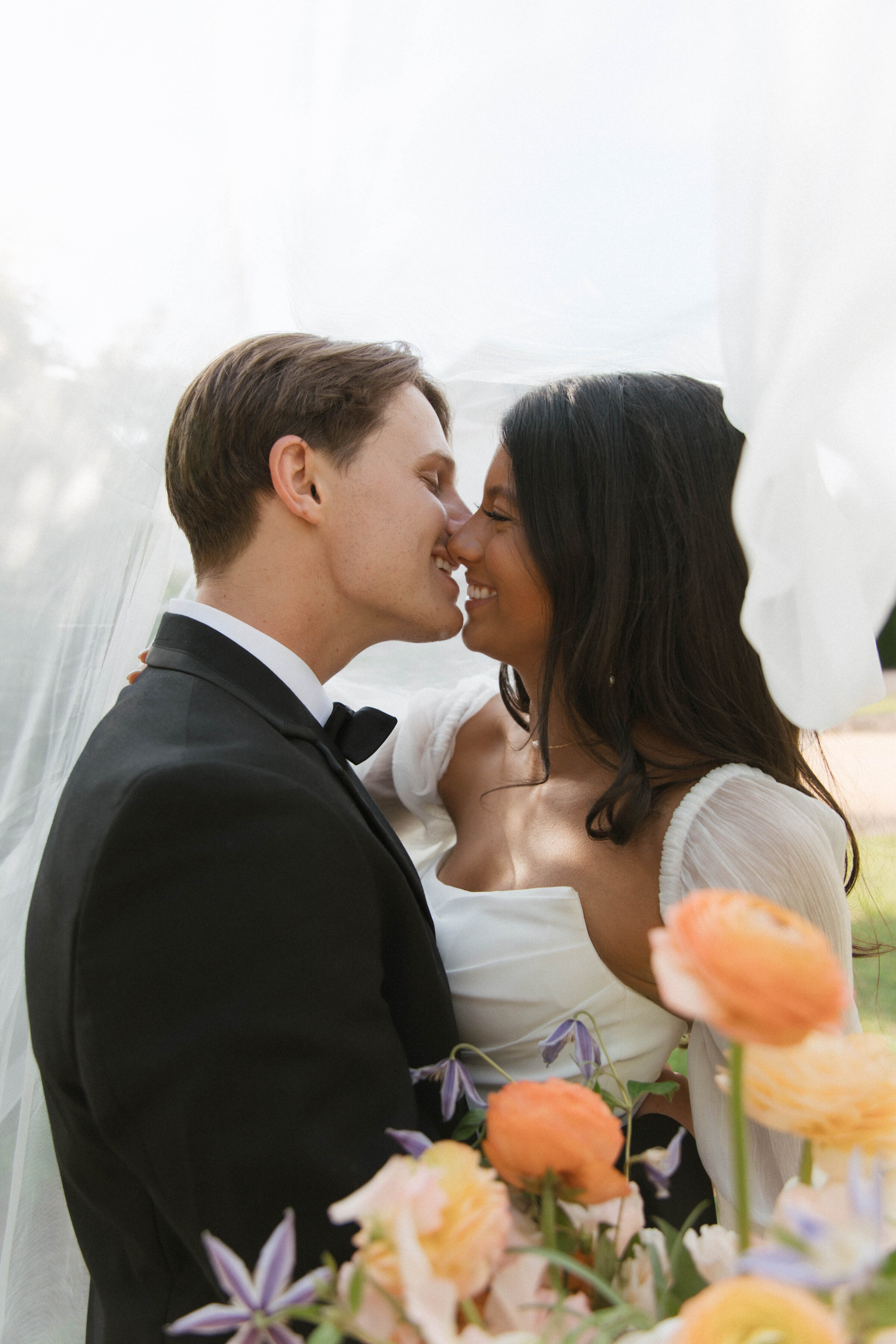 bride and groom kissing under veil