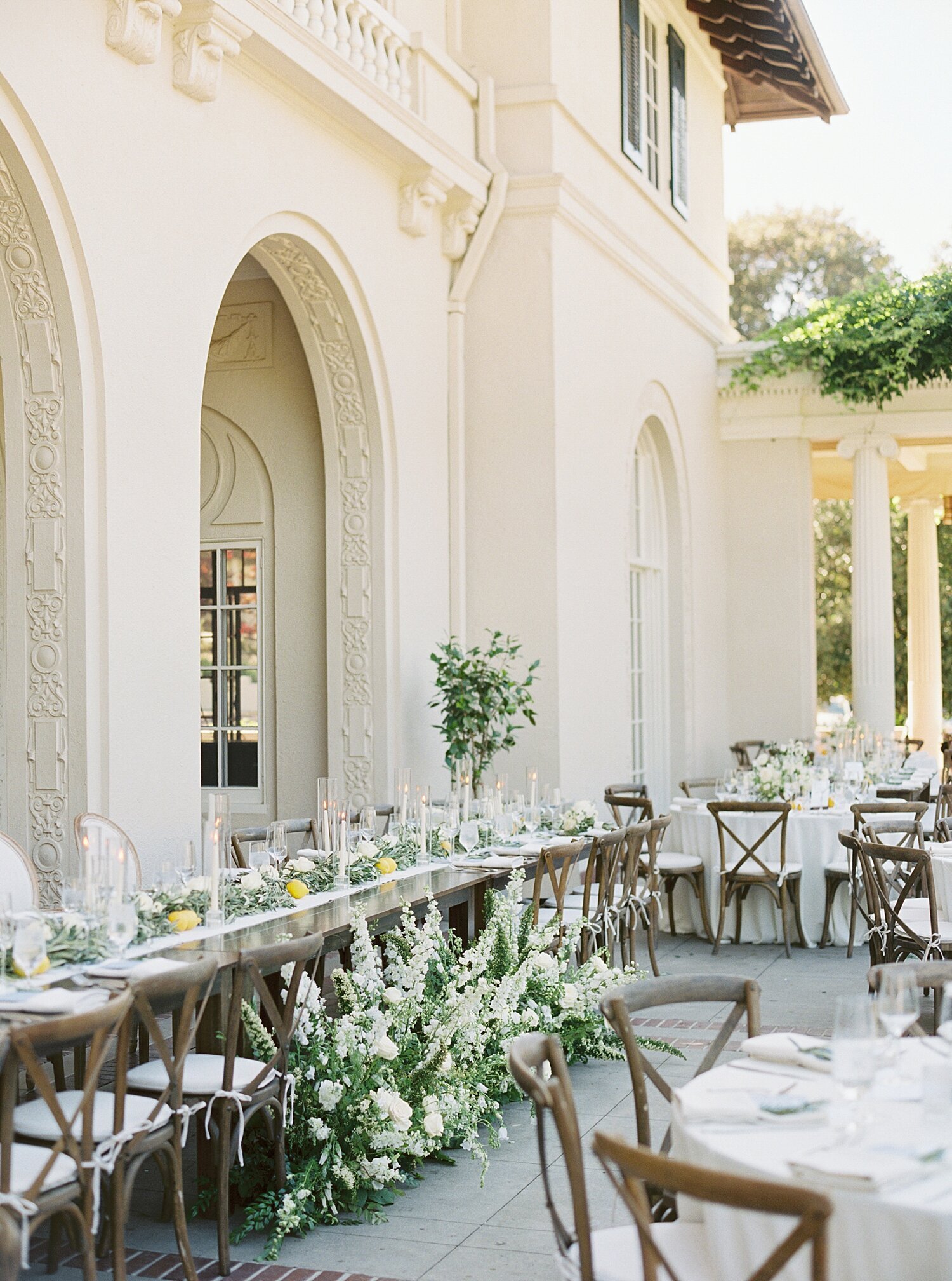 Spanish Villa architecture and wedding tables with green and white florals at reception