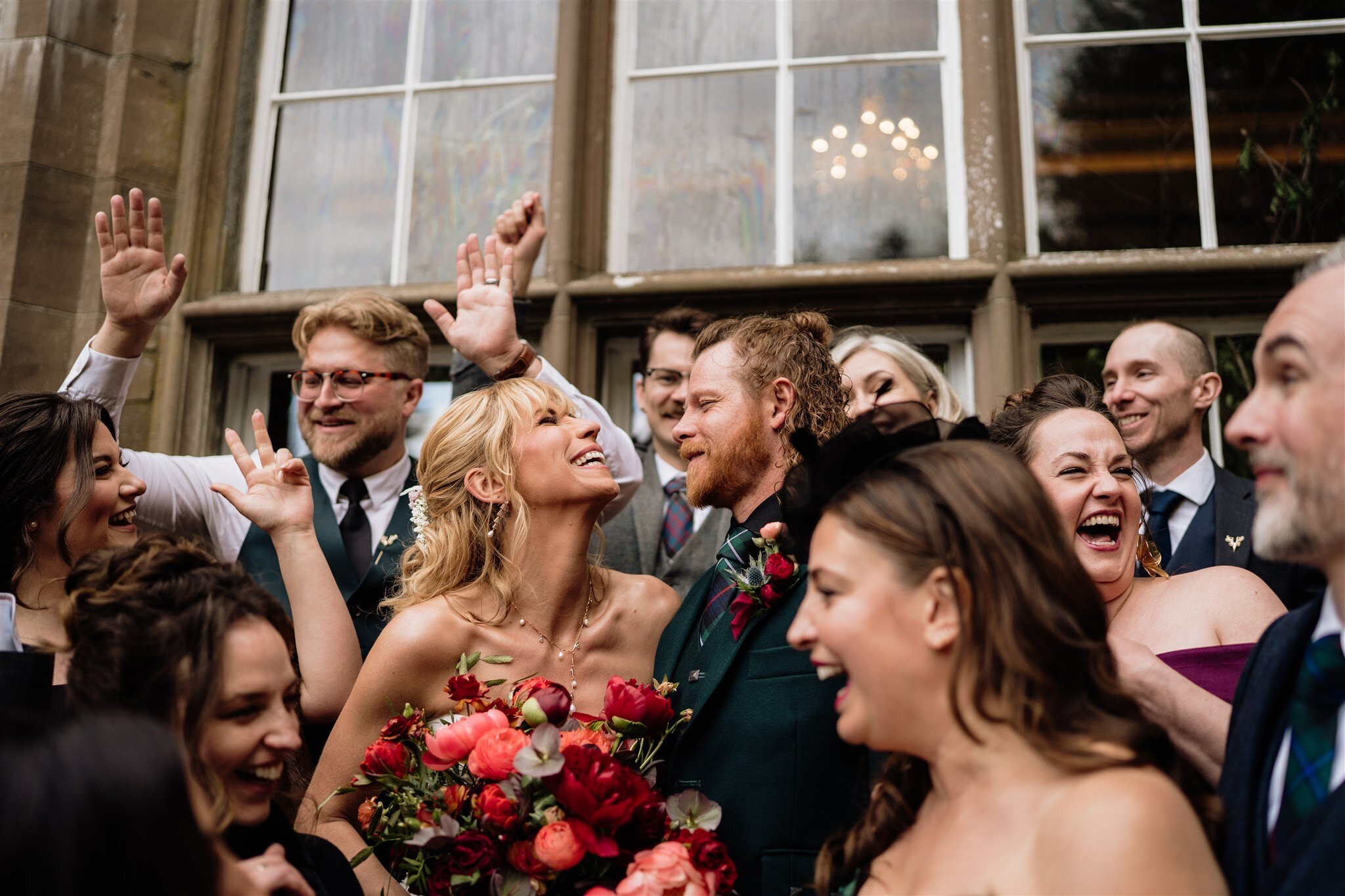 A bride and groom are photographed surrounded by friends outside Drumtochty Castle in Aberdeenshire after their wedding.