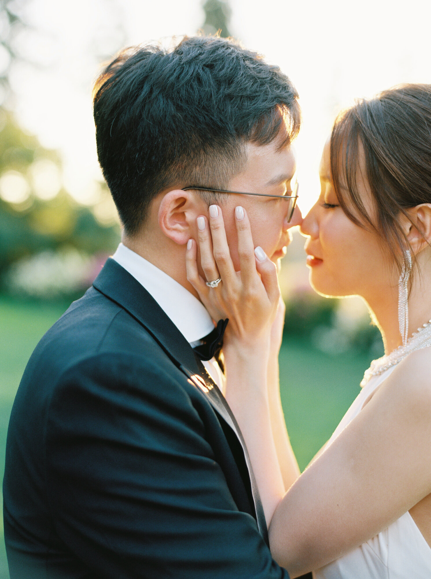 Chinese bride and groom snuggle faces during golden hour