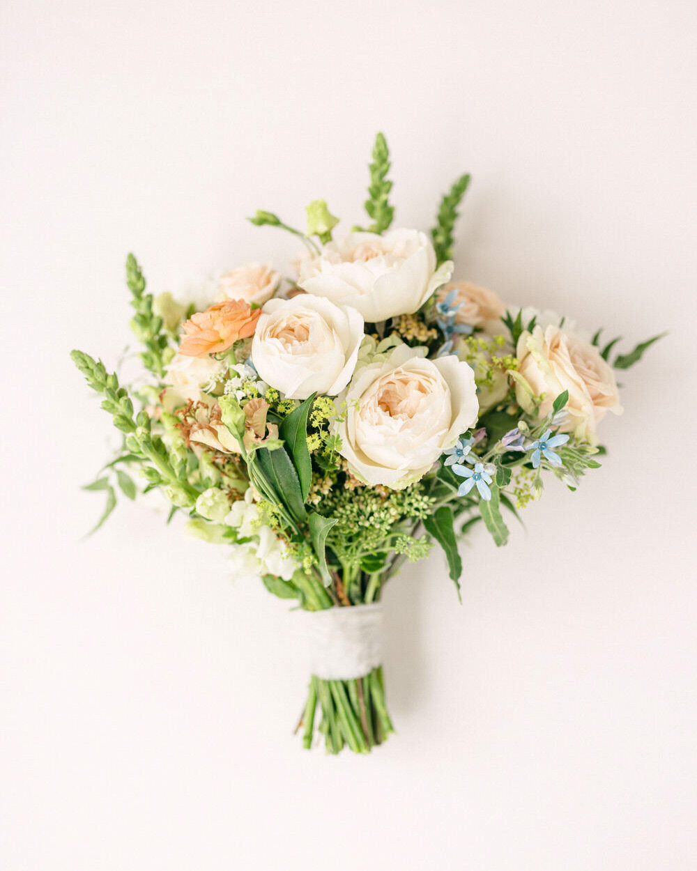 This elegant layflat photo showcases the bride's bouquet, part of her wedding day details, captured by a luxury editorial photographer. The intricate arrangement of the flowers reflects the sophistication and attention to detail that mark this special day, highlighting the photographer’s skill in portraying luxury and elegance.