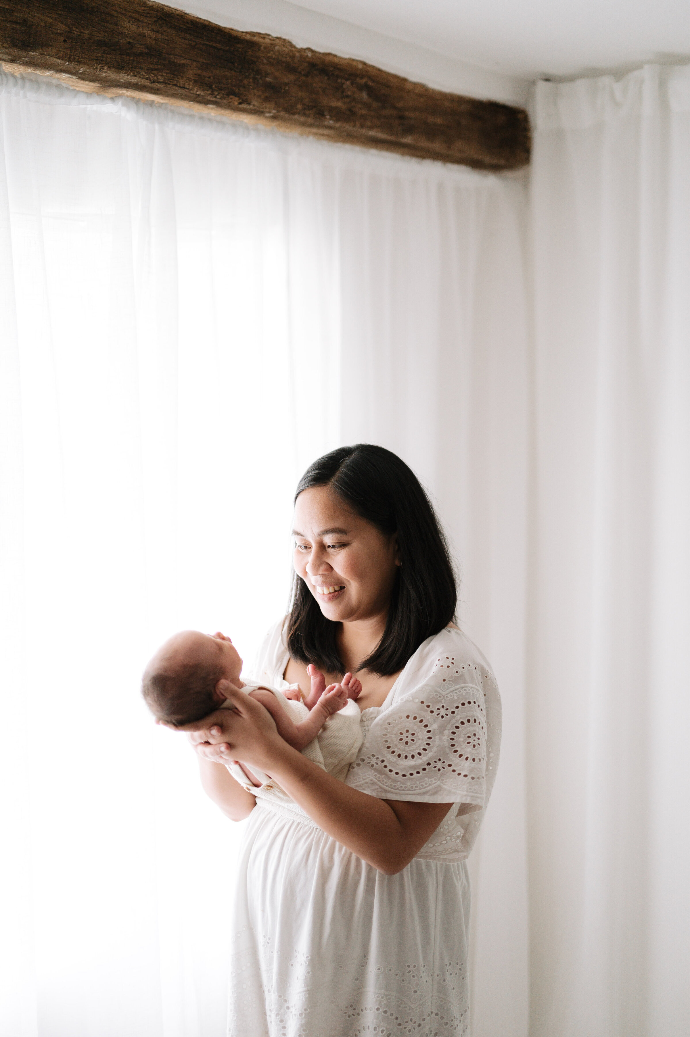 A new mum holding her newborn daughter at Billingshurst photoshoot