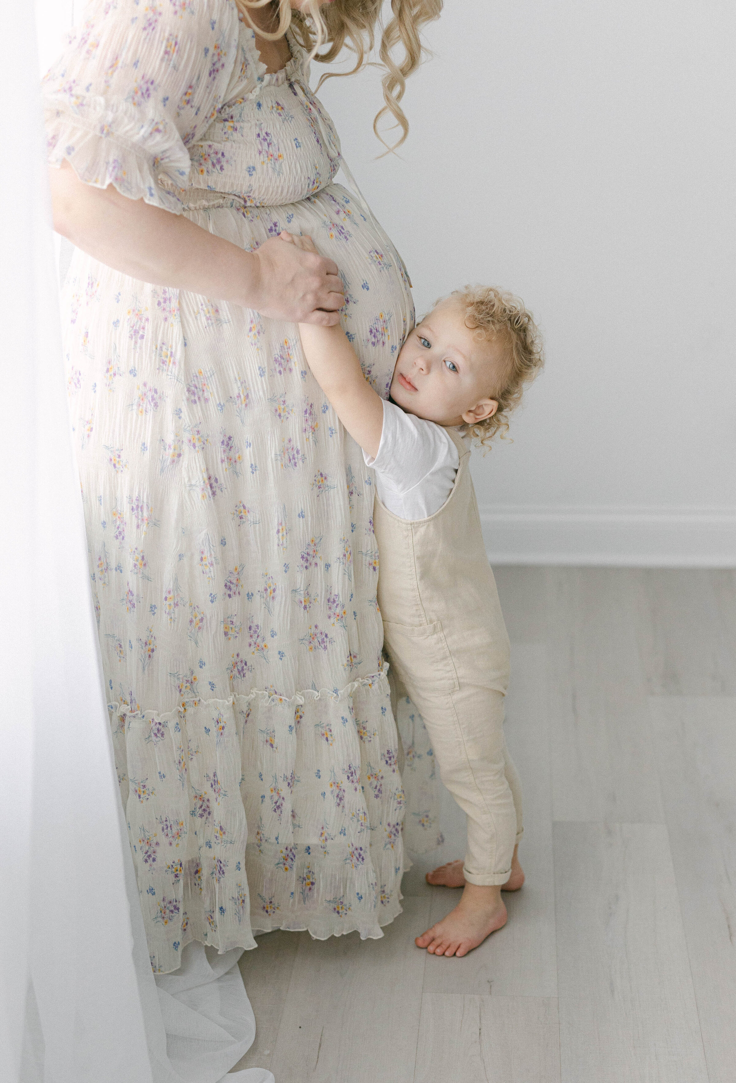 little boy holding womens pregnant belly smiling at camera knoxville tennessee newborn photographer