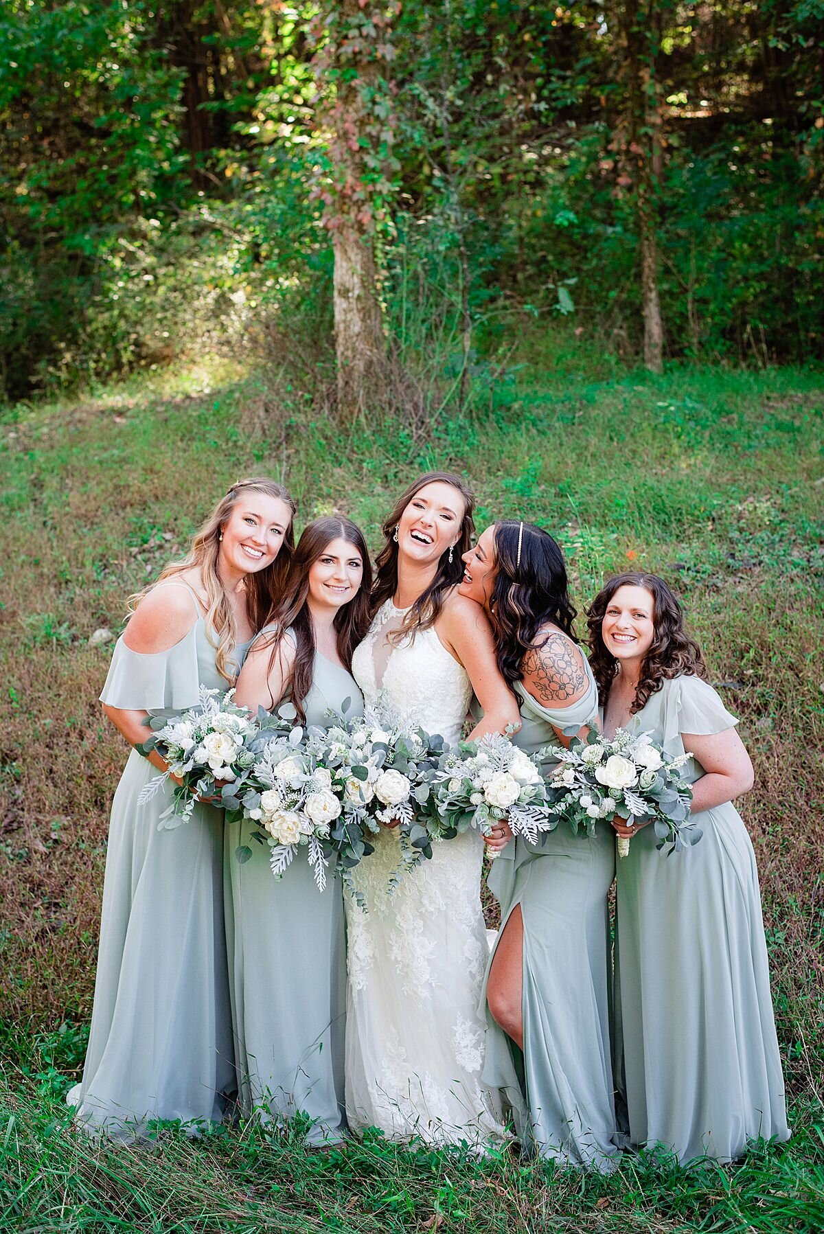 Bridesmaids wearing a soft eucalyptus shade dress and laughing alongside a bride in a valley