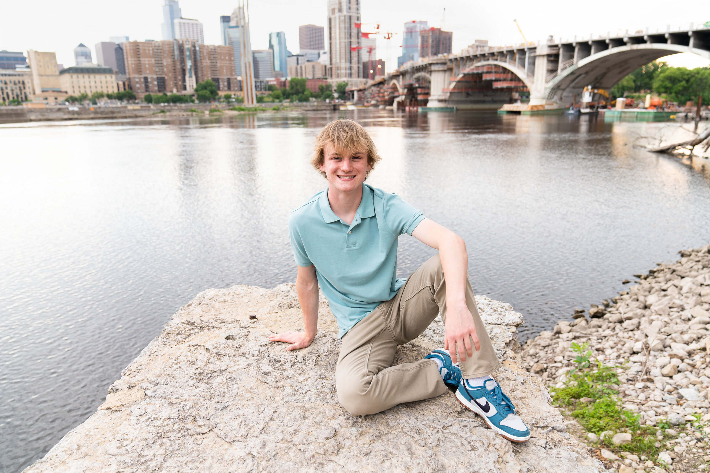 Senior picture of guy with Minneapolis skyline in the background