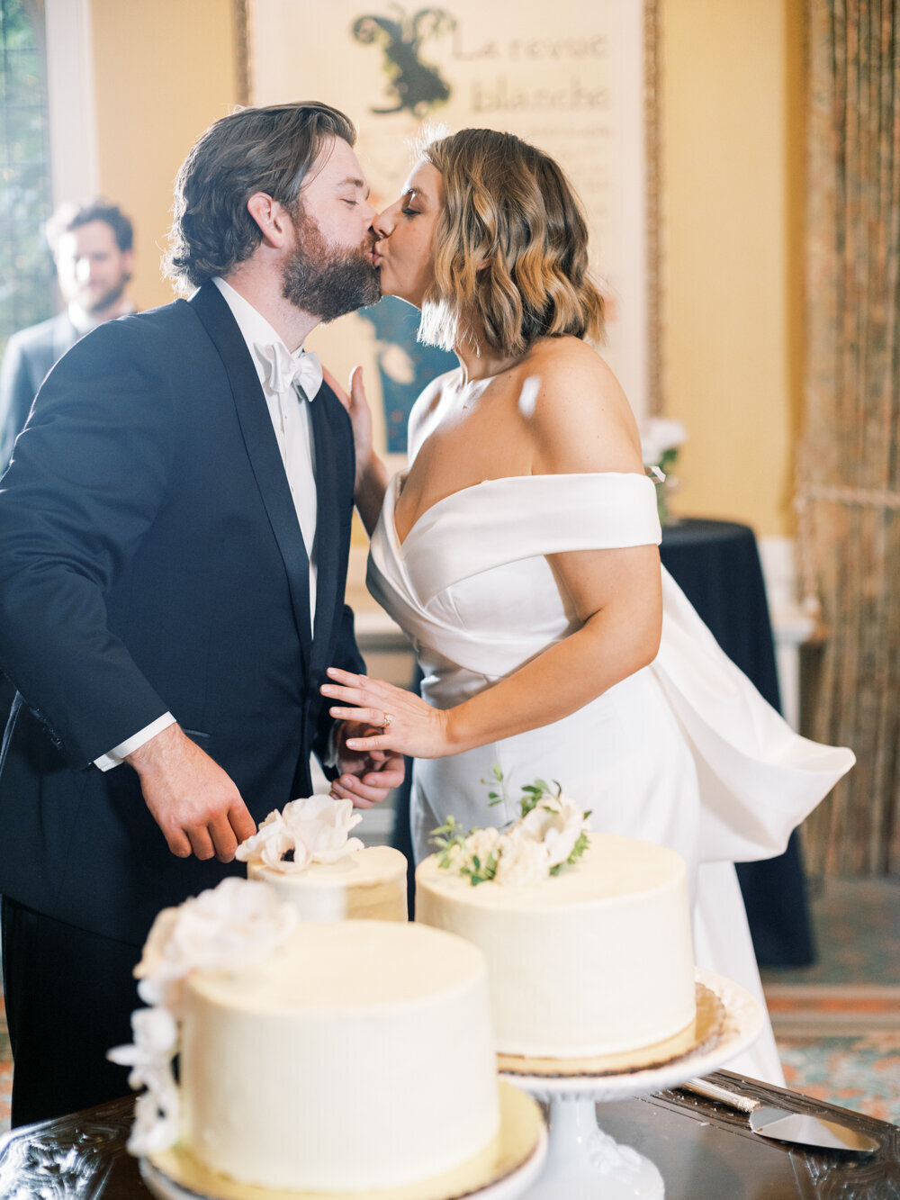 bride and groom kissing near cake photographed using off camera flash