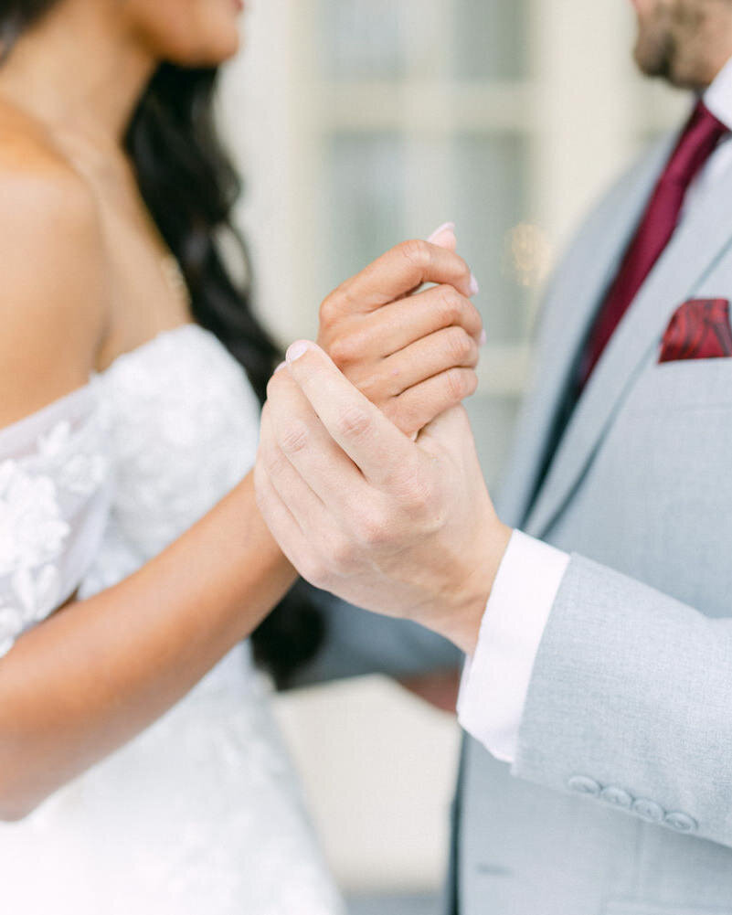 This heartfelt image captures the bride and groom holding hands during their first look in the beautiful conservatory at the Banff Springs Hotel. The natural light and stunning surroundings create a perfect setting for this emotional and intimate moment.