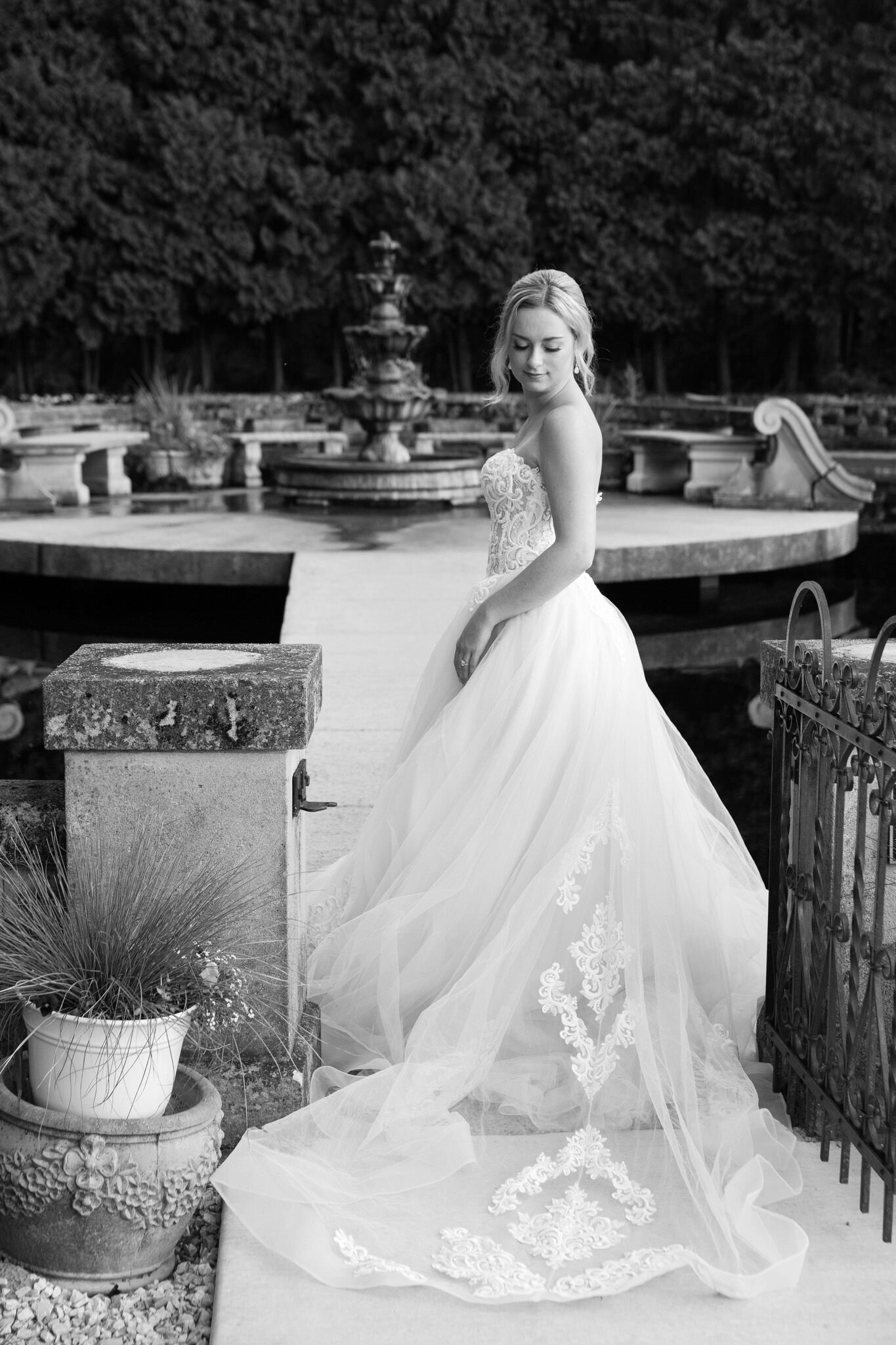 black and white picture of a bride in front of a water fountain