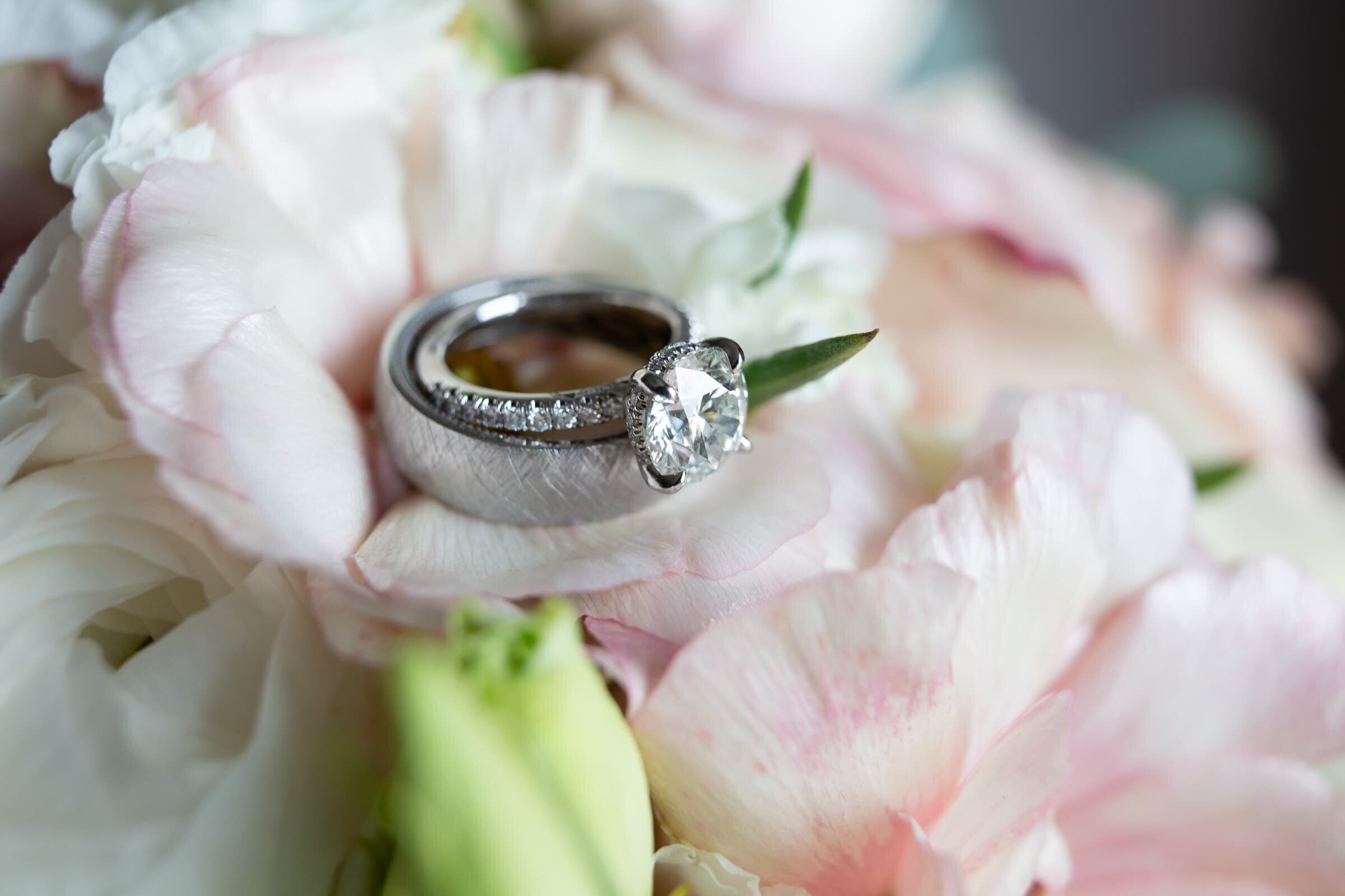 wedding rings on flowers , merrimon wynne raleigh wedding photography
